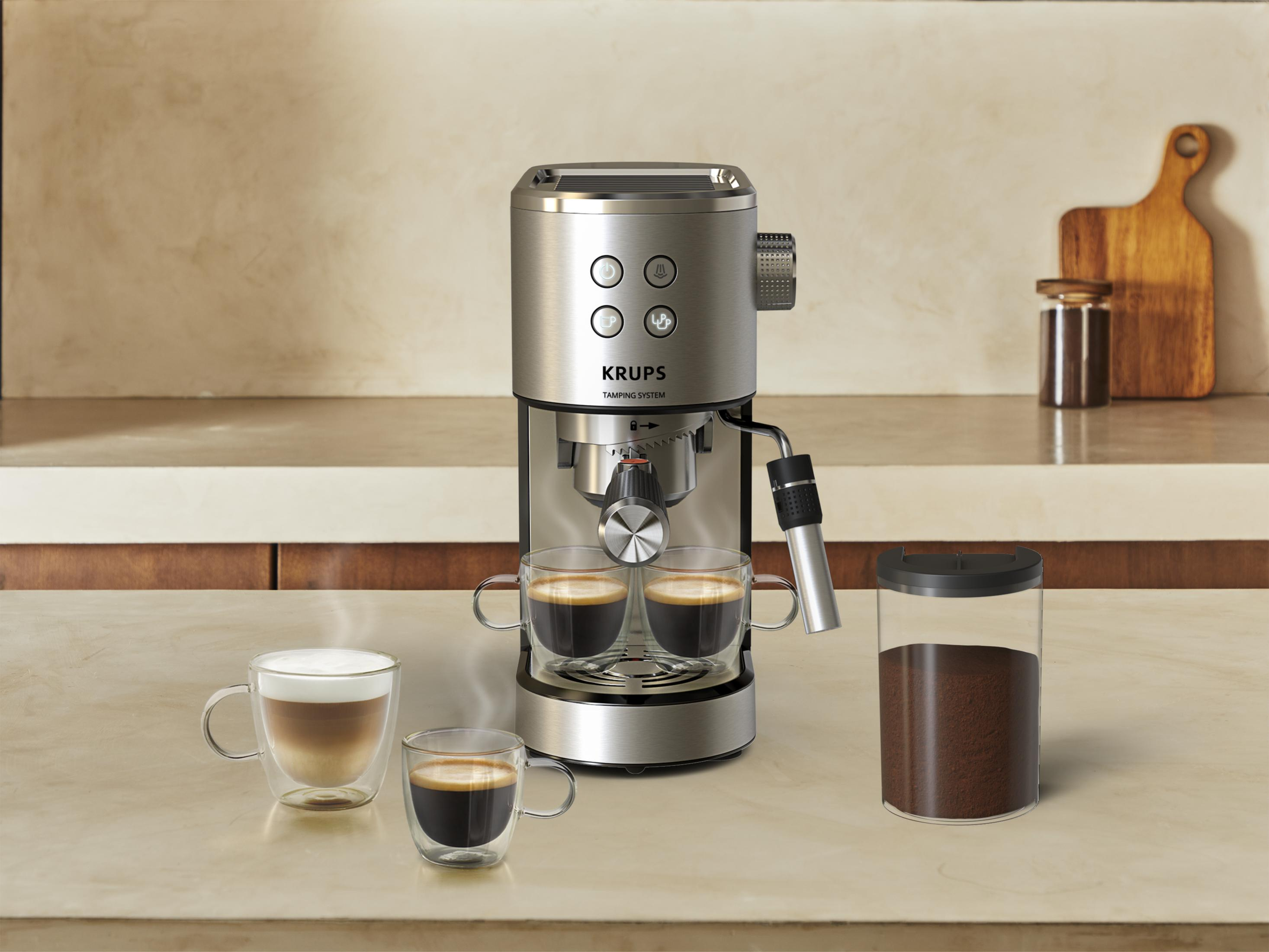Una macchina per espresso Krups argentata prepara caffè in due tazze.