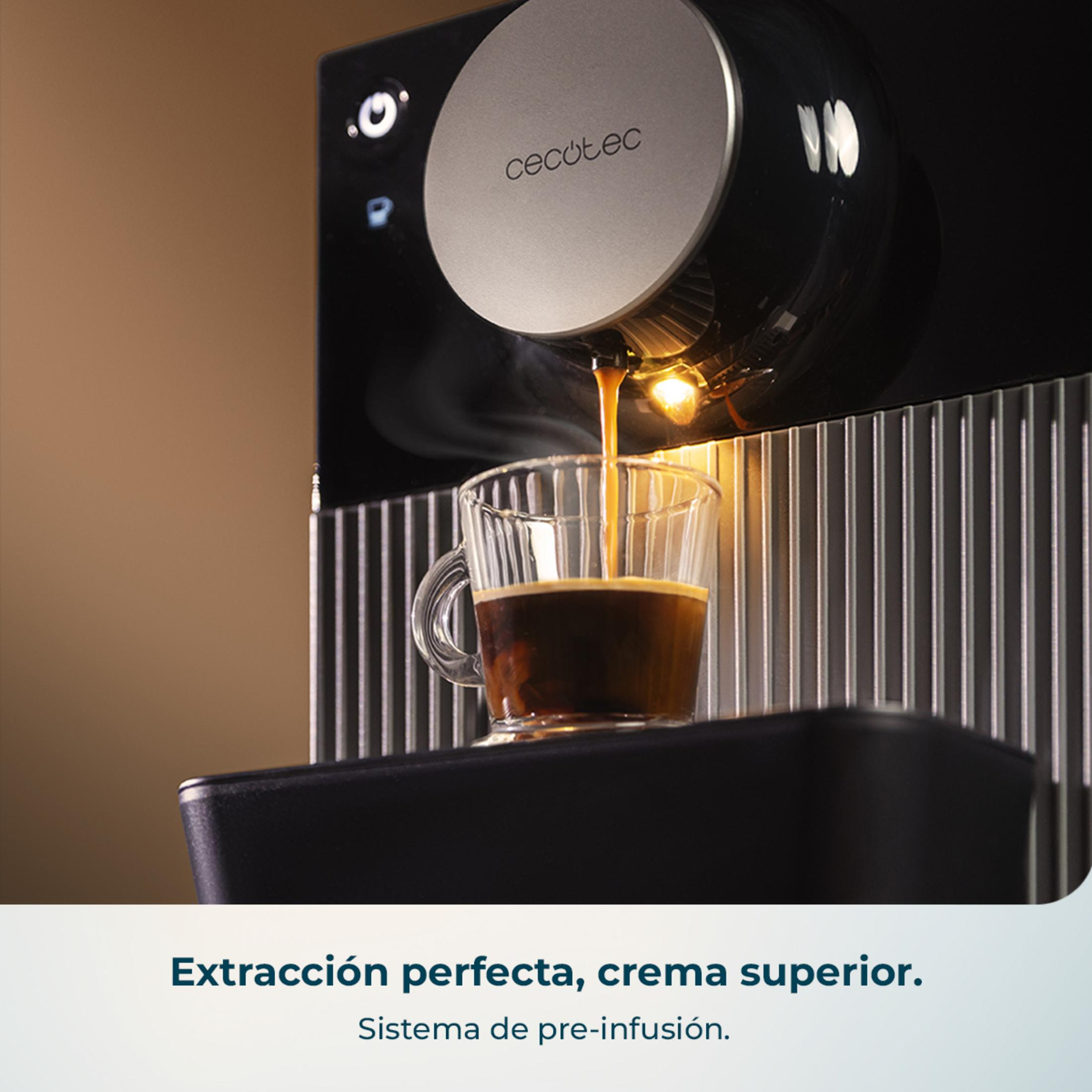 Cafetera preparando café en una taza de cristal. El vapor sube.