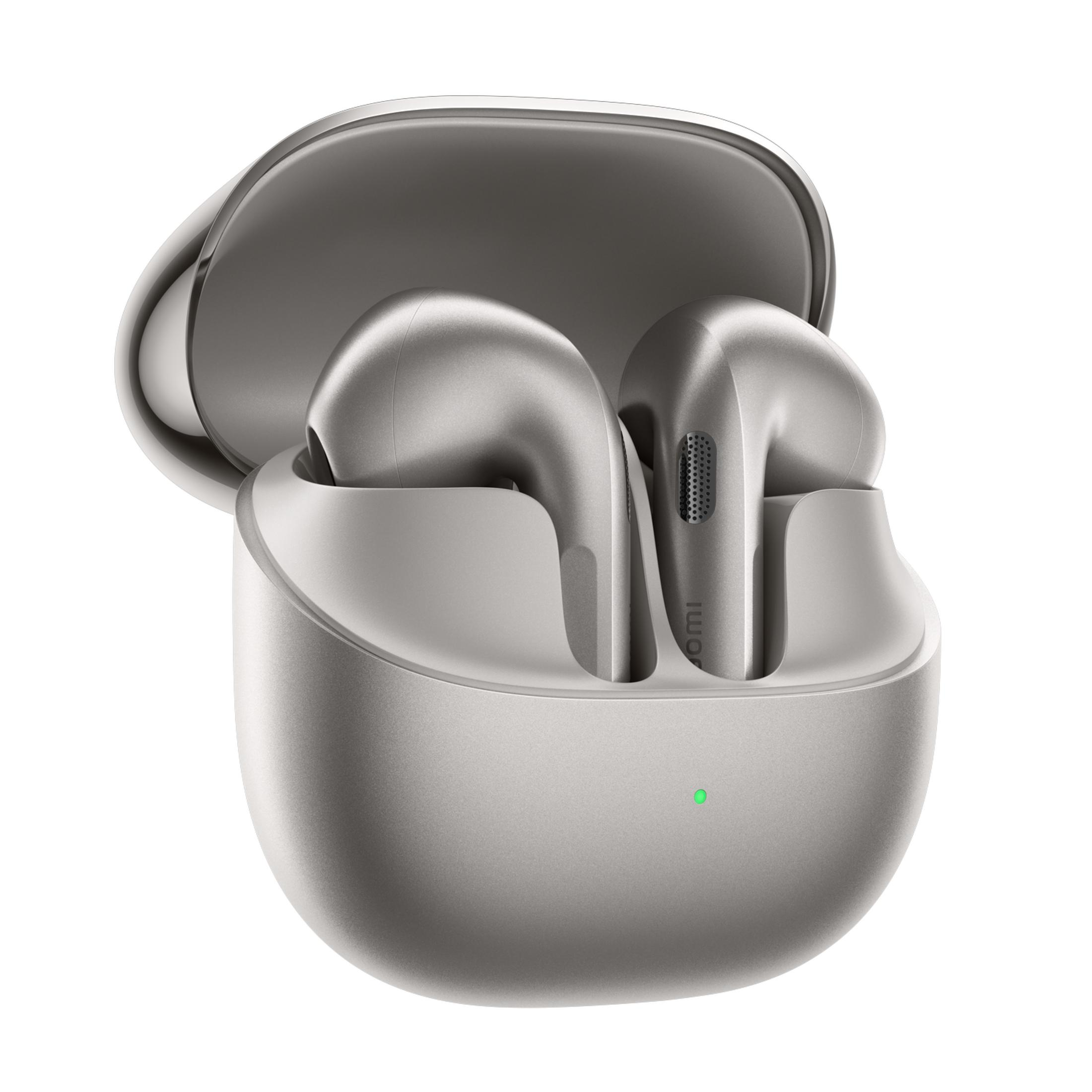 Auriculares inalámbricos plateados en su estuche de carga abierto con luz verde.