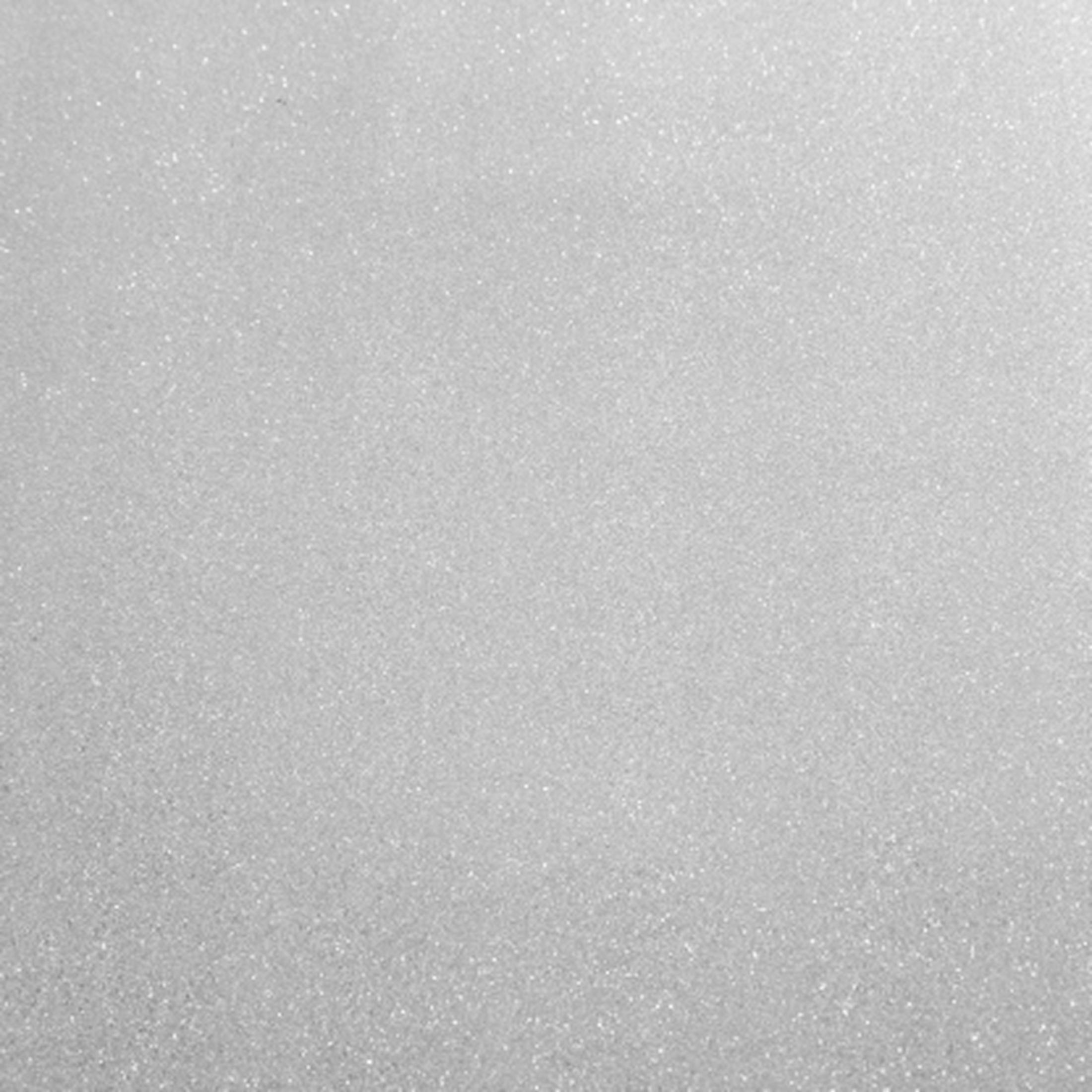 Finas partículas de purpurina blanca sobre un fondo gris claro.
