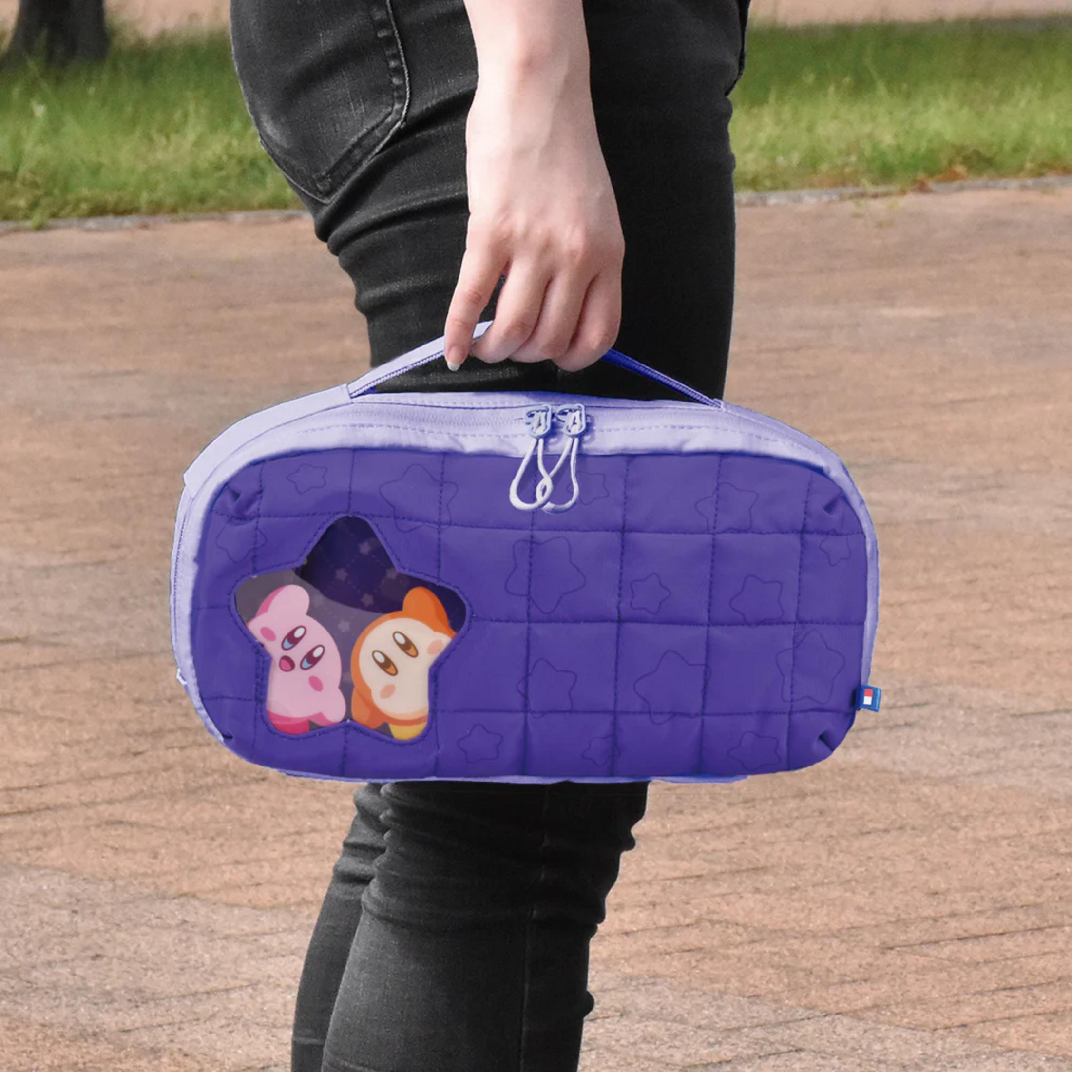 Una persona sostiene una bolsa morada acolchada con patrón de estrellas y Kirby.