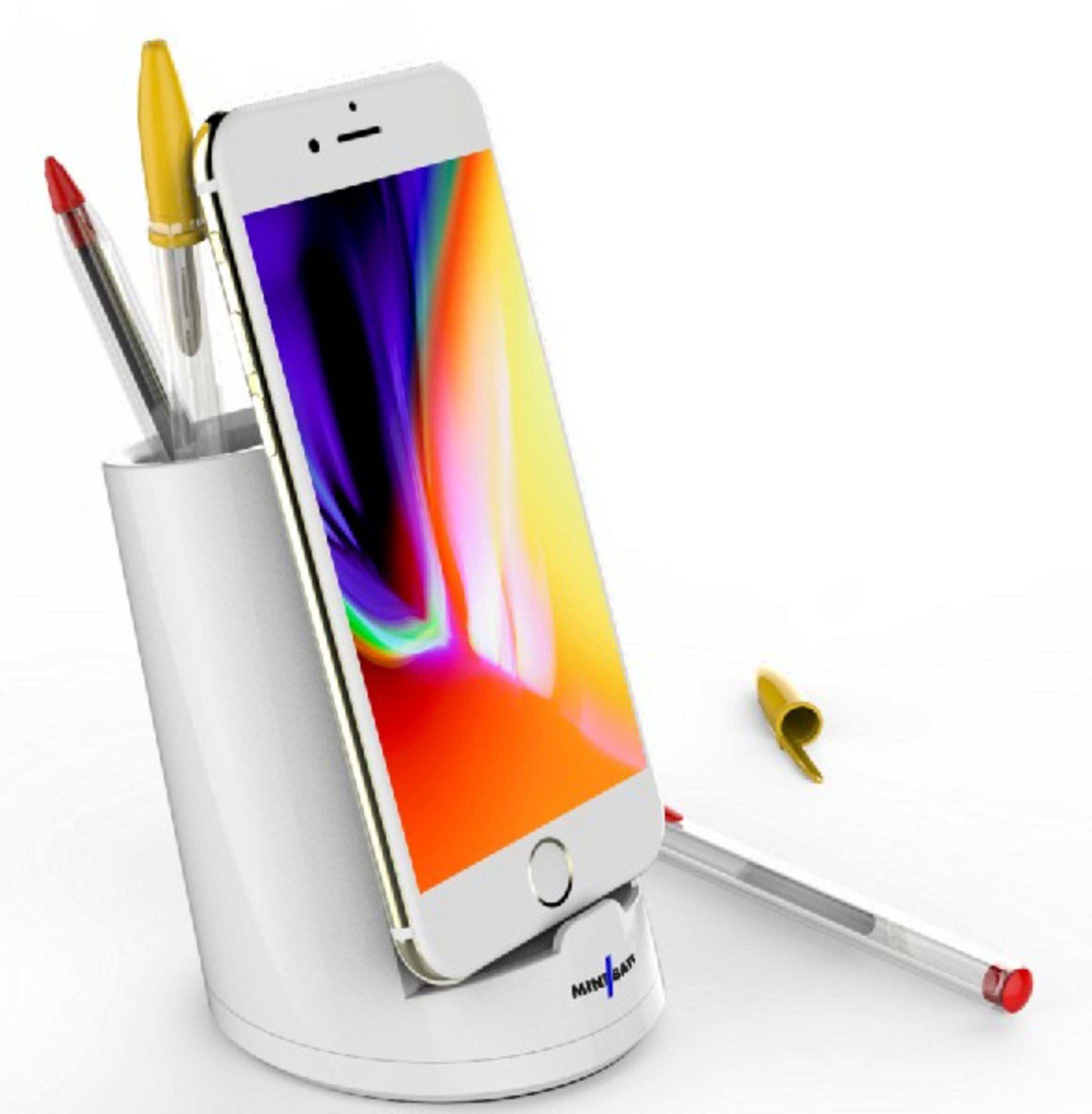 Un soporte blanco para teléfono con un teléfono y bolígrafos.