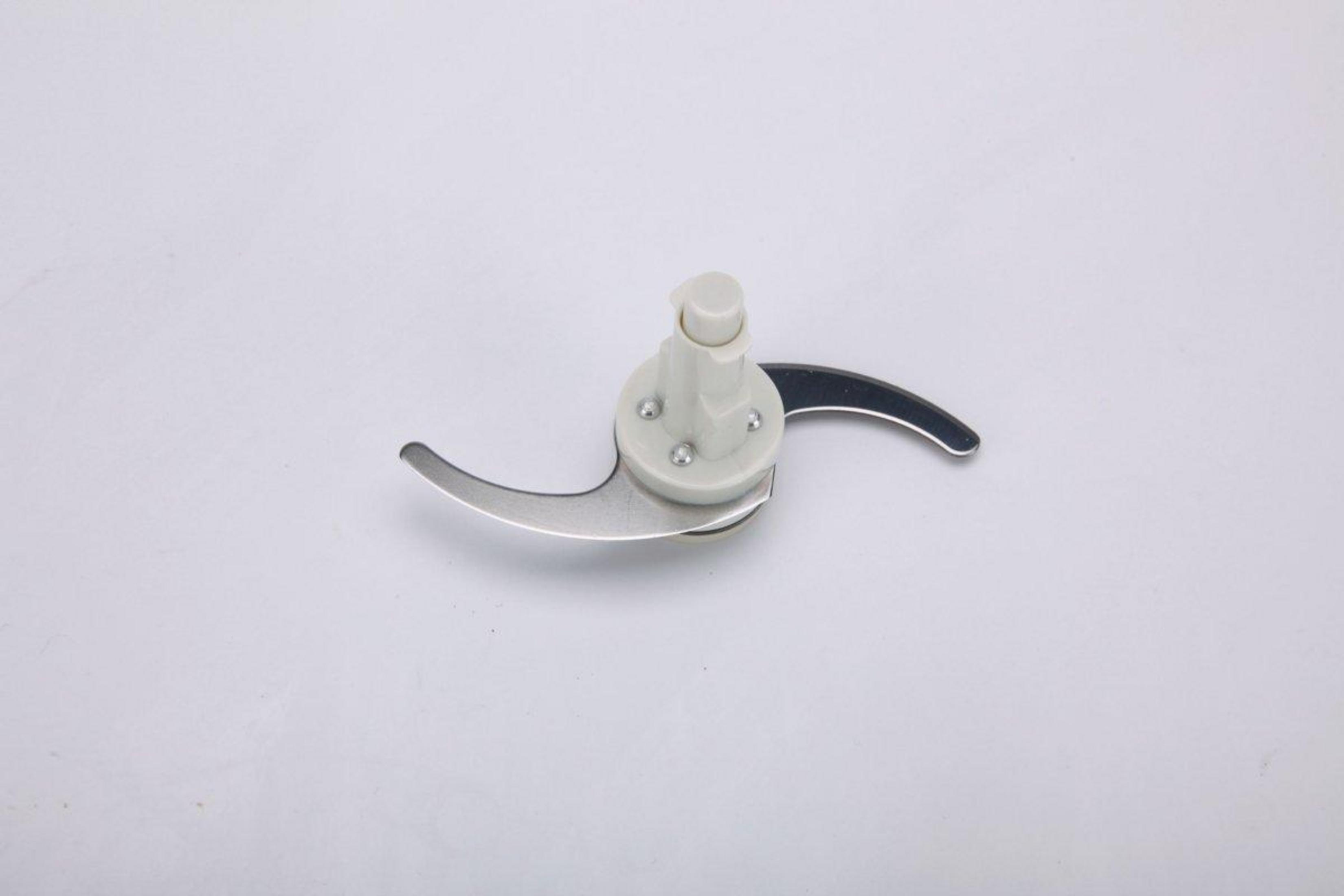 Un accesorio blanco para licuadora con dos cuchillas plateadas afiladas sobre fondo blanco.