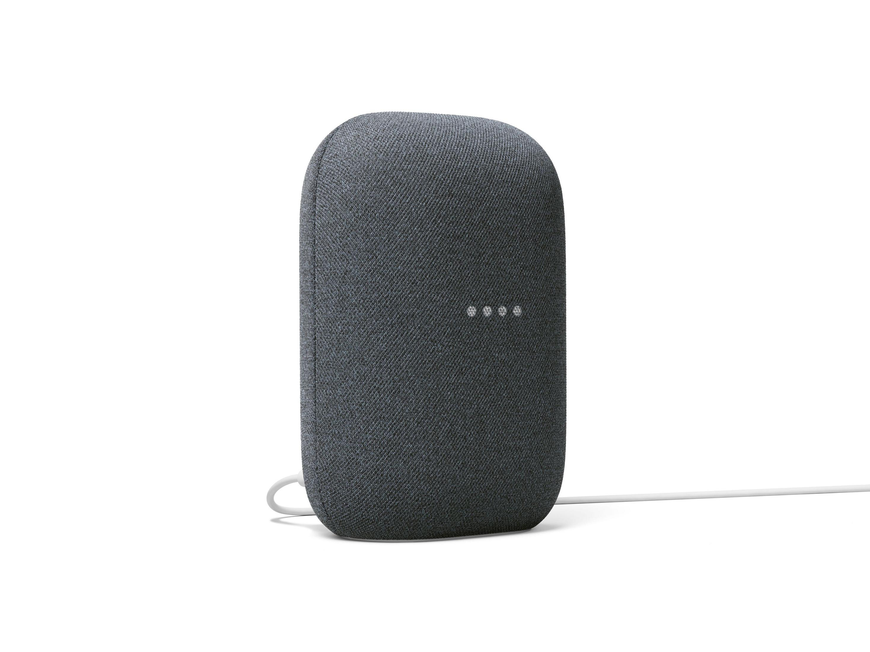 Altavoz de tela gris oscuro con cuatro luces y cable blanco.