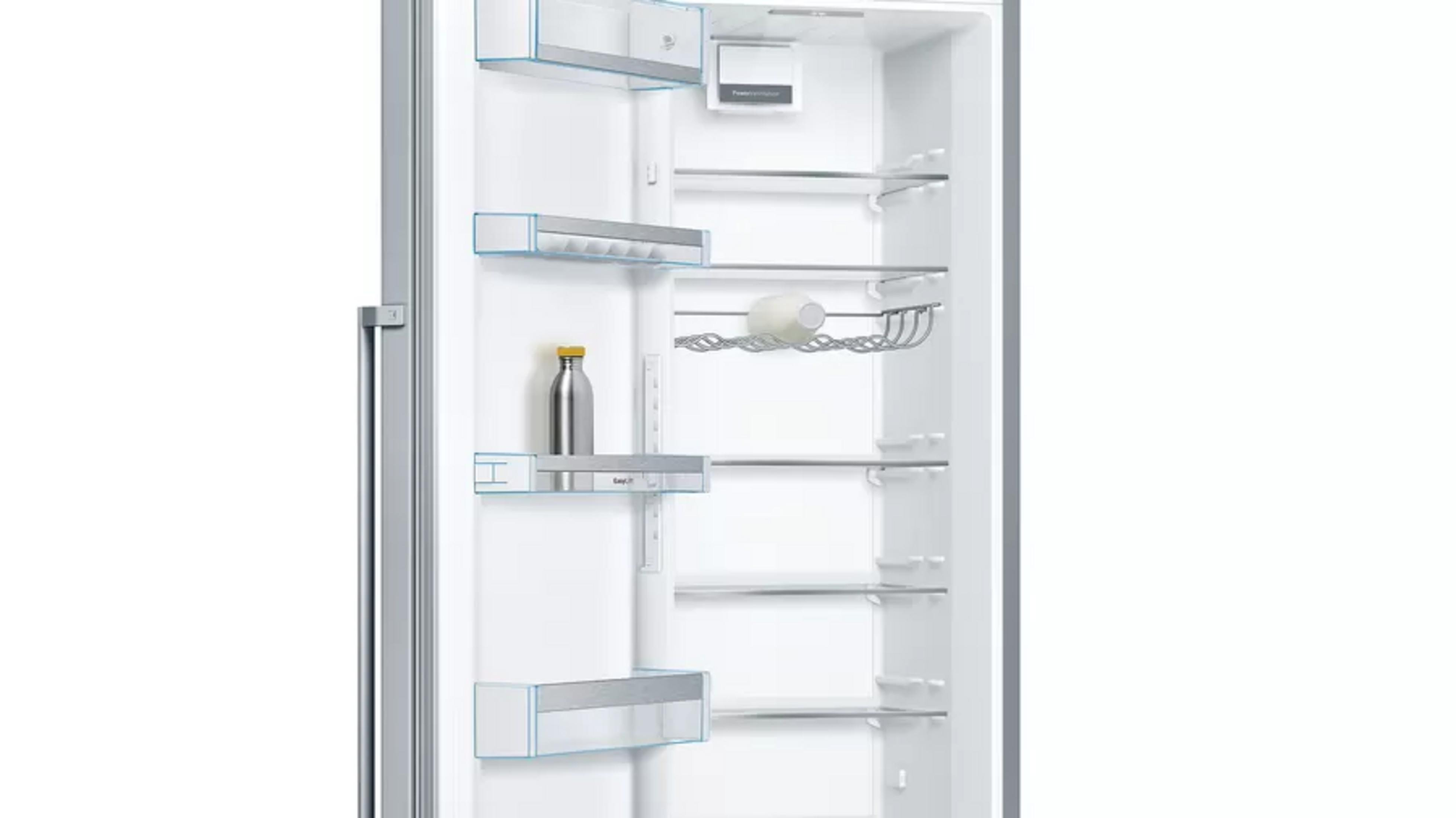 Refrigerador abierto con botella plateada y botella de leche en estantes.