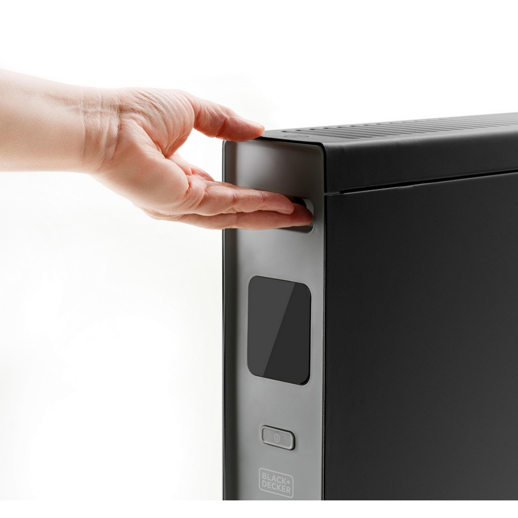 Eine Hand drückt einen Knopf an einem schwarzen Black+Decker Gerät.