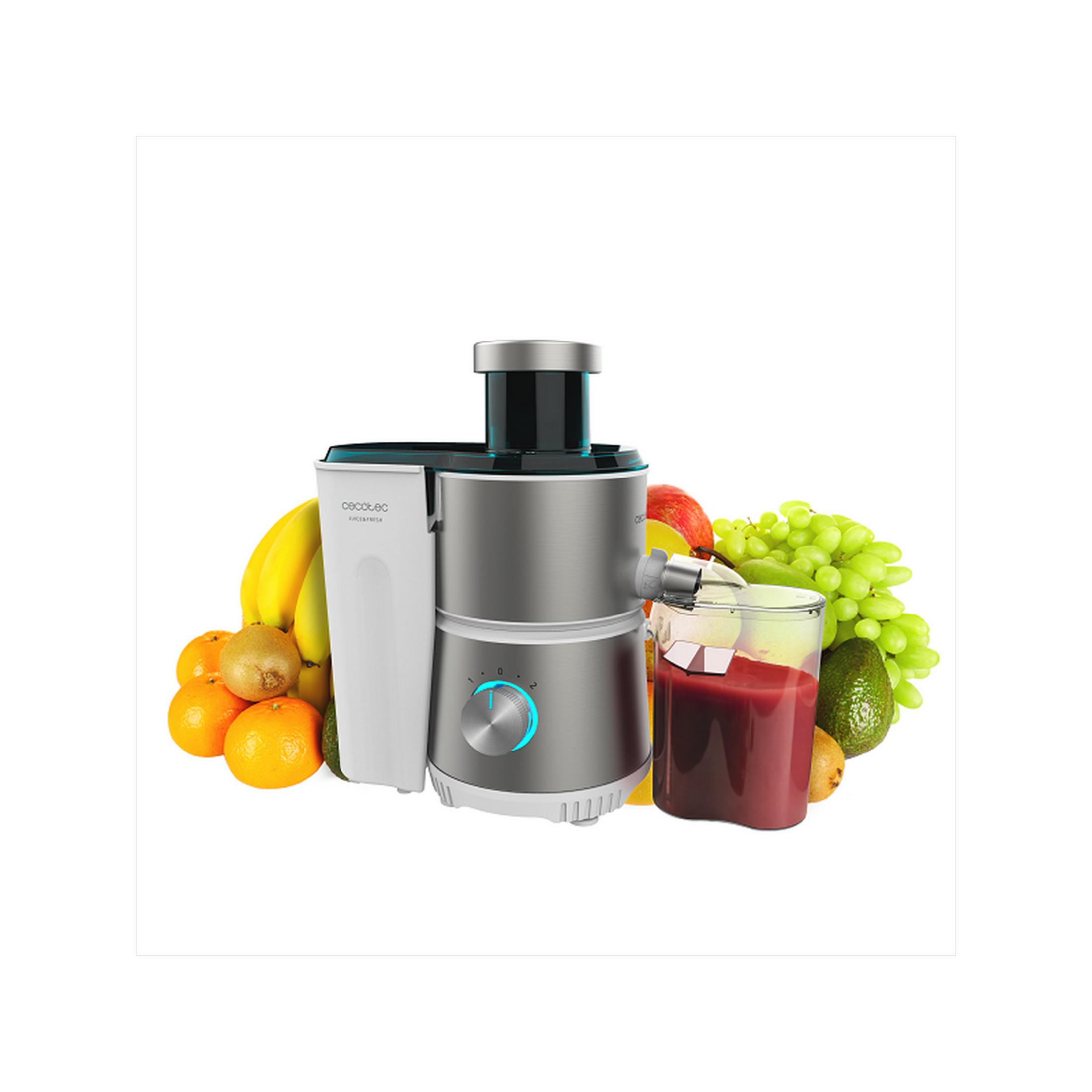 Spremiagrumi argento con frutta: banane, arance, kiwi, uva, avocado e un bicchiere di succo.