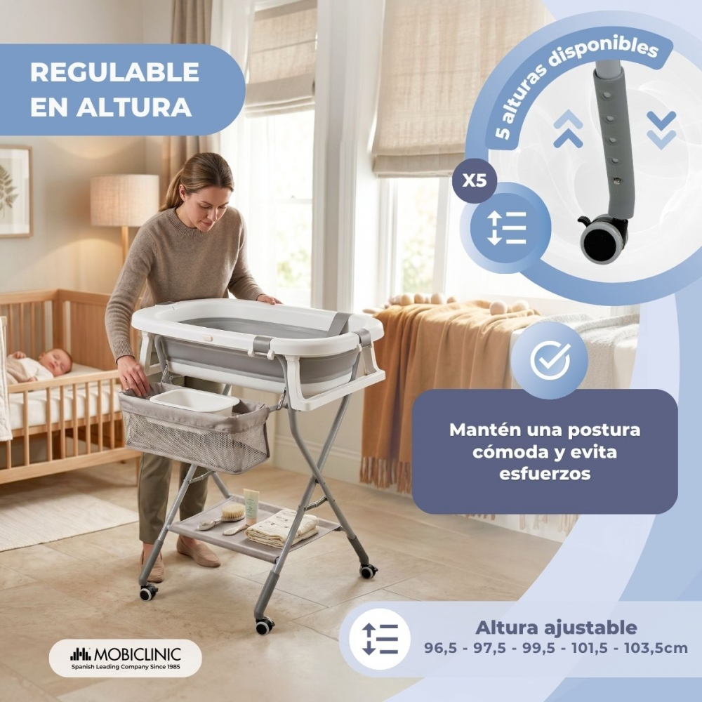 Una mujer ajusta una bañera para bebé en un soporte regulable en altura junto a una cuna.