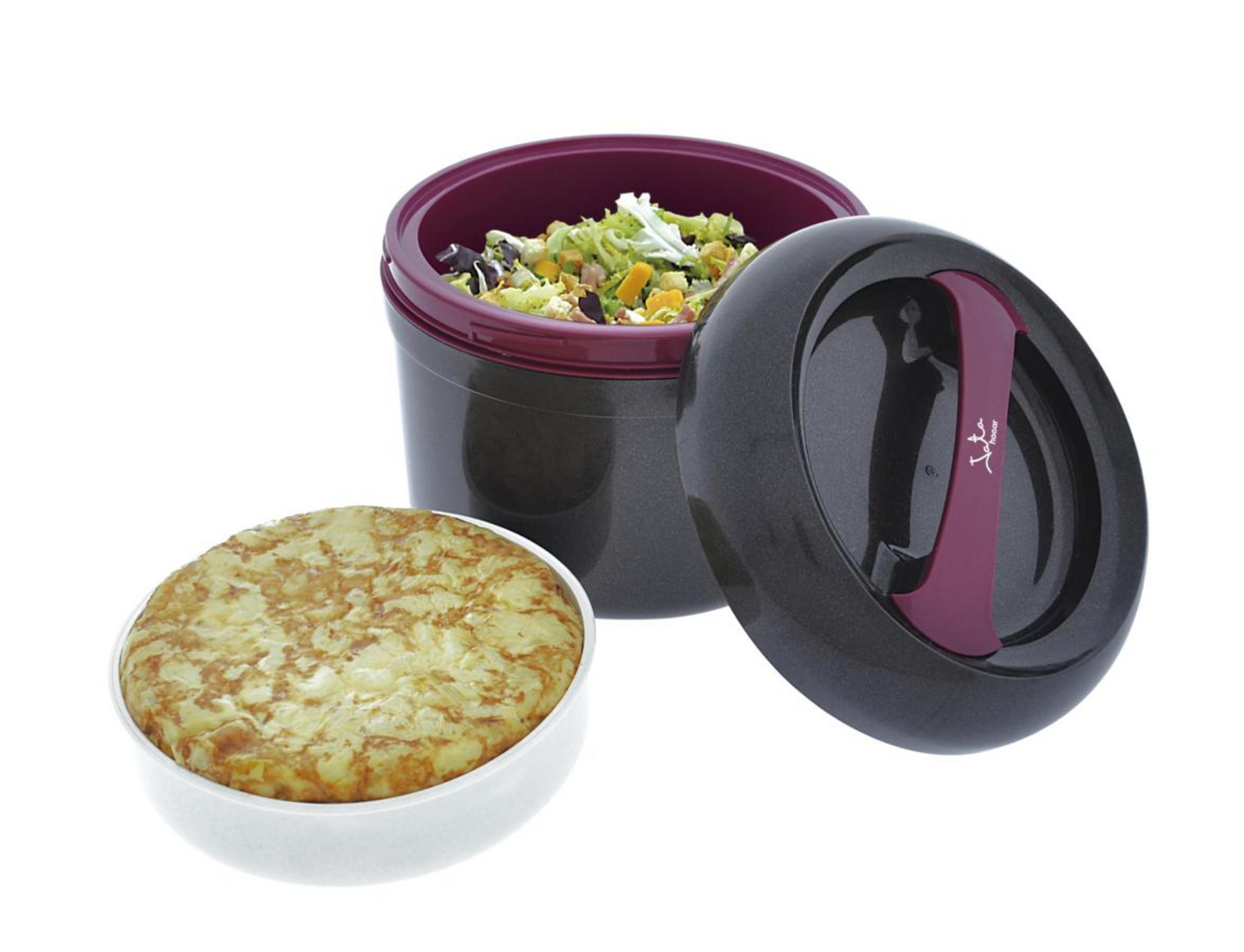 Ein dunkler Behälter mit Salat und ein runder Kuchen daneben.