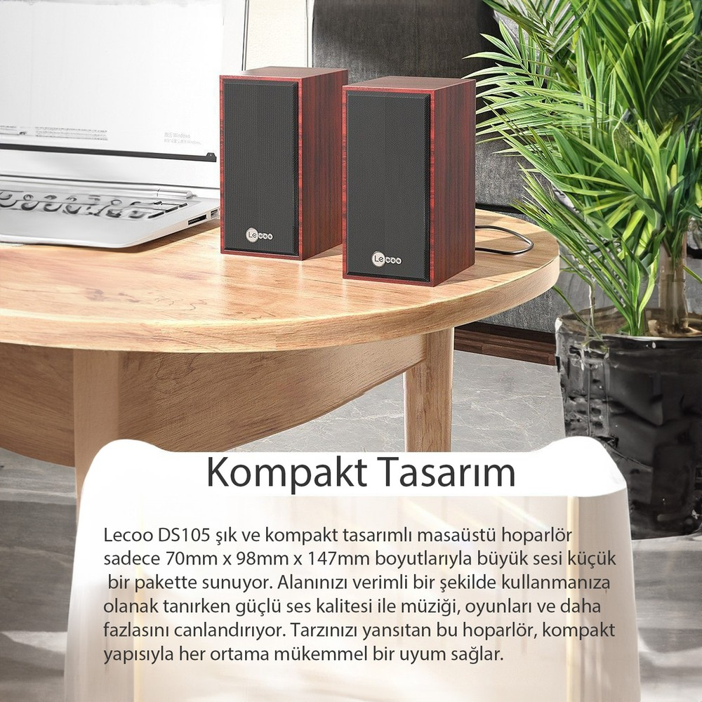Ahşap görünümlü iki hoparlör, laptop ve bitki ile masada.