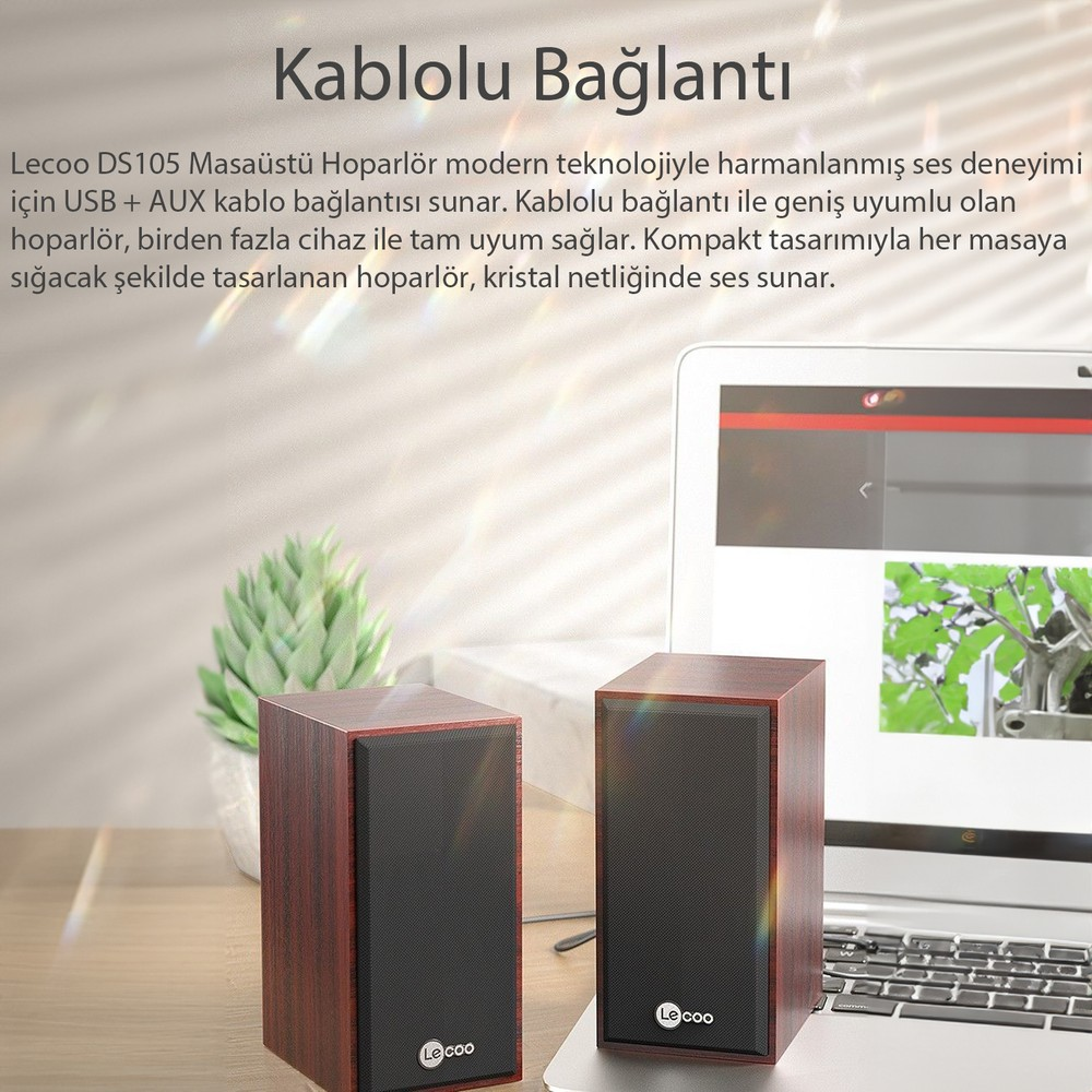 İki kahverengi ahşap hoparlör, dizüstü bilgisayarın yanında masada duruyor.