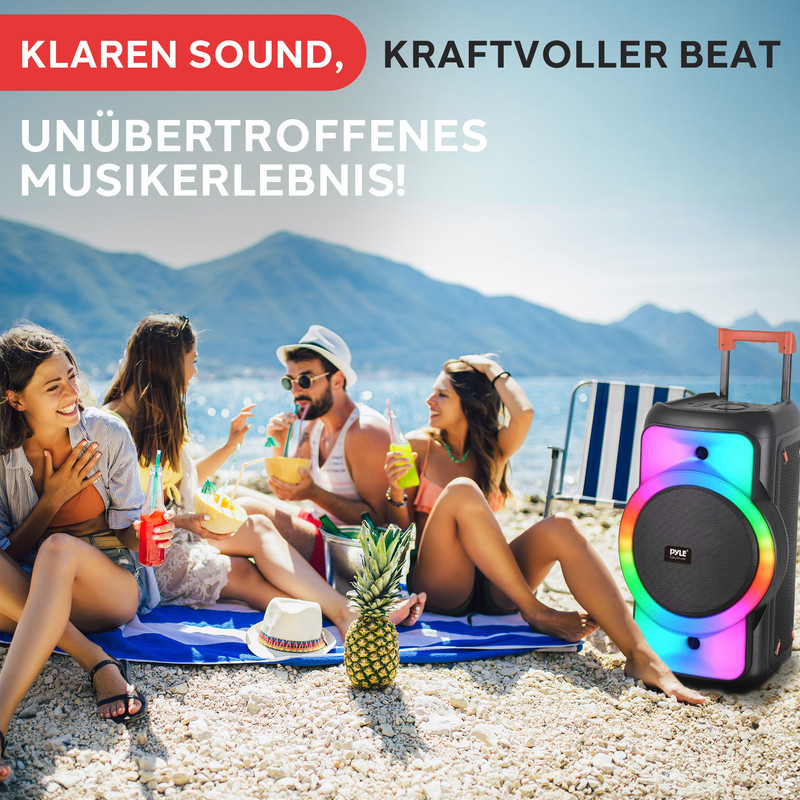 Vier Freunde am Strand mit einem tragbaren Lautsprecher und Getränken.