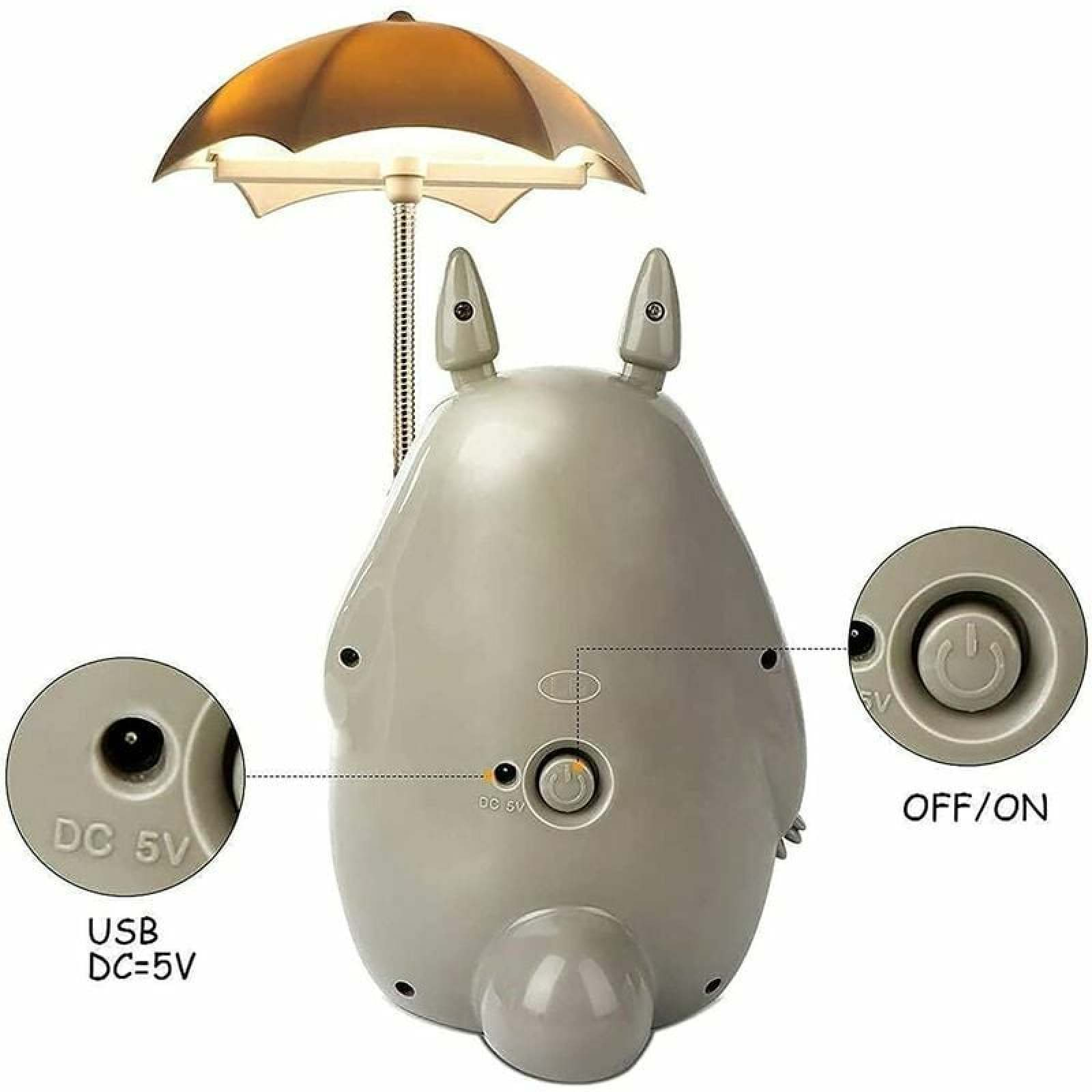 Eine graue Lampe in Totoro-Form mit einem Schirm, zeigt USB- und EIN/AUS-Anschlüsse.