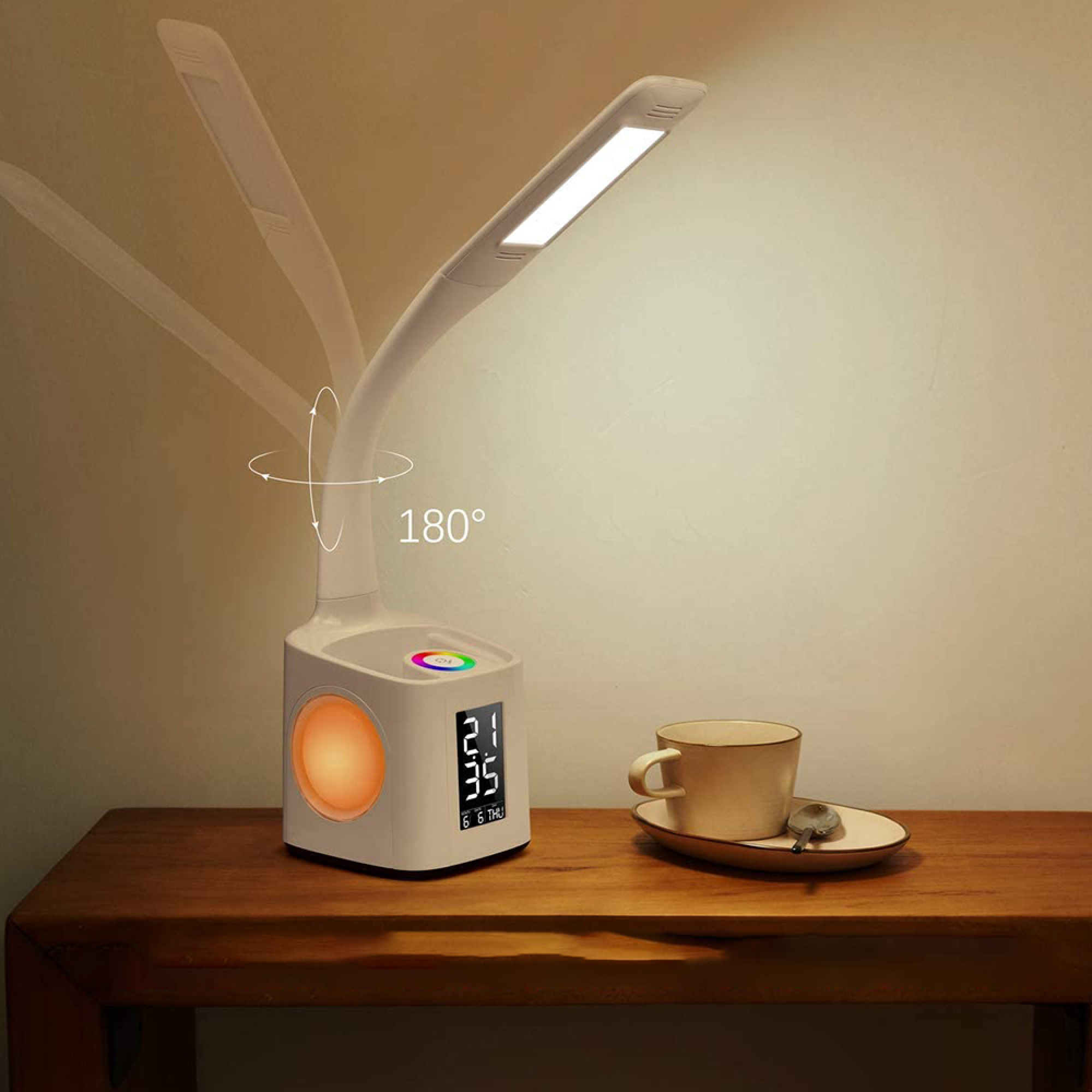 Eine weiße Schreibtischlampe mit digitaler Anzeige, einem Farb-LED-Ring und einer Tasse Kaffee.