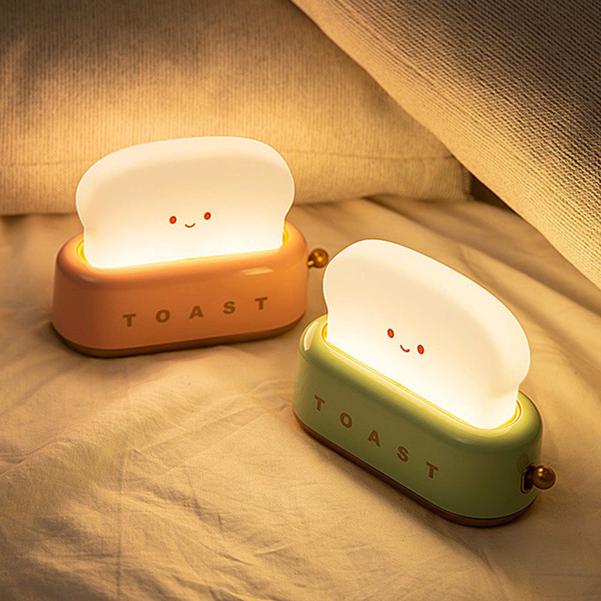 Zwei Toast-Nachtlichter mit Gesichtern auf einem Bett.