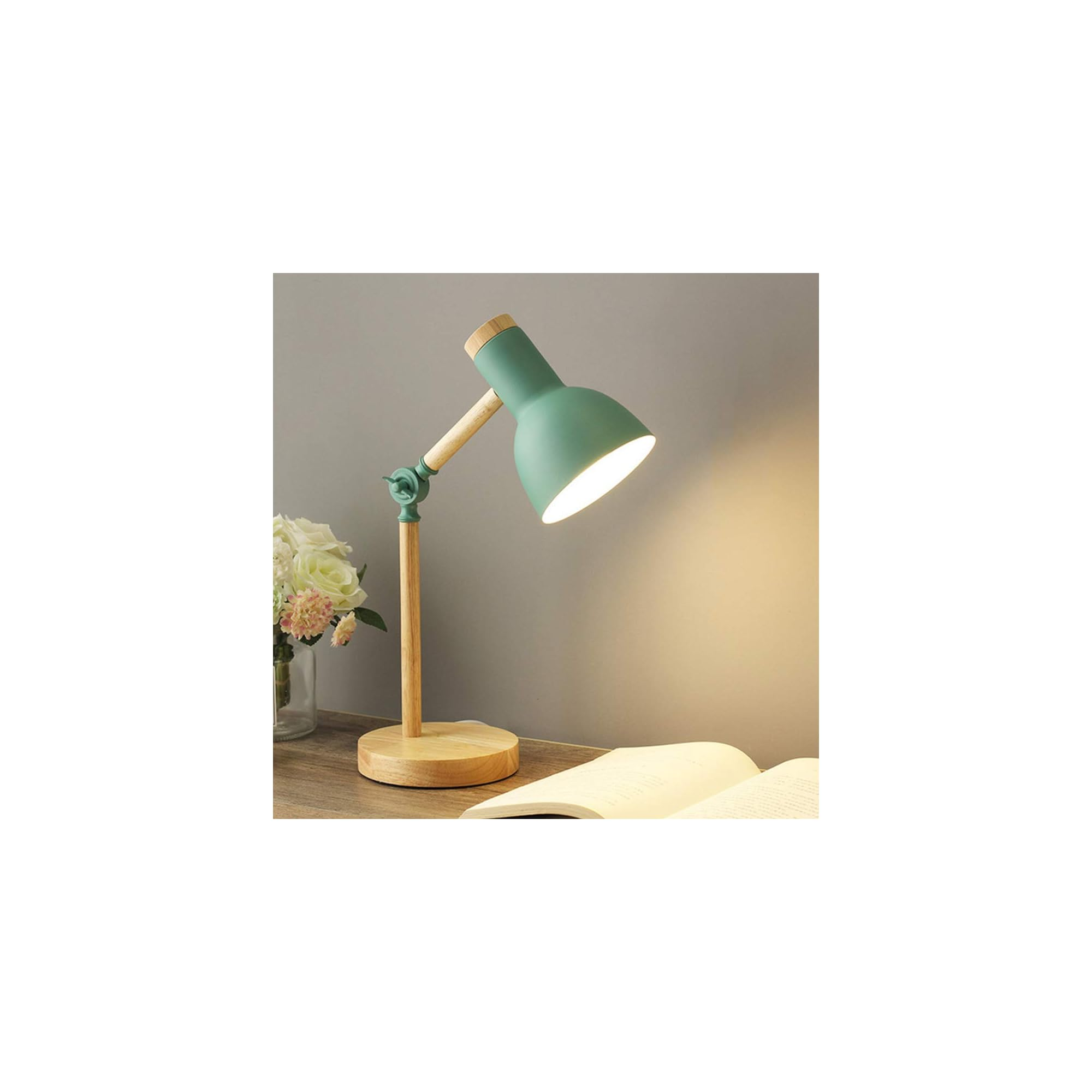 Grüne Schreibtischlampe aus Holz auf einem Nachttisch mit Buch und Blumen.