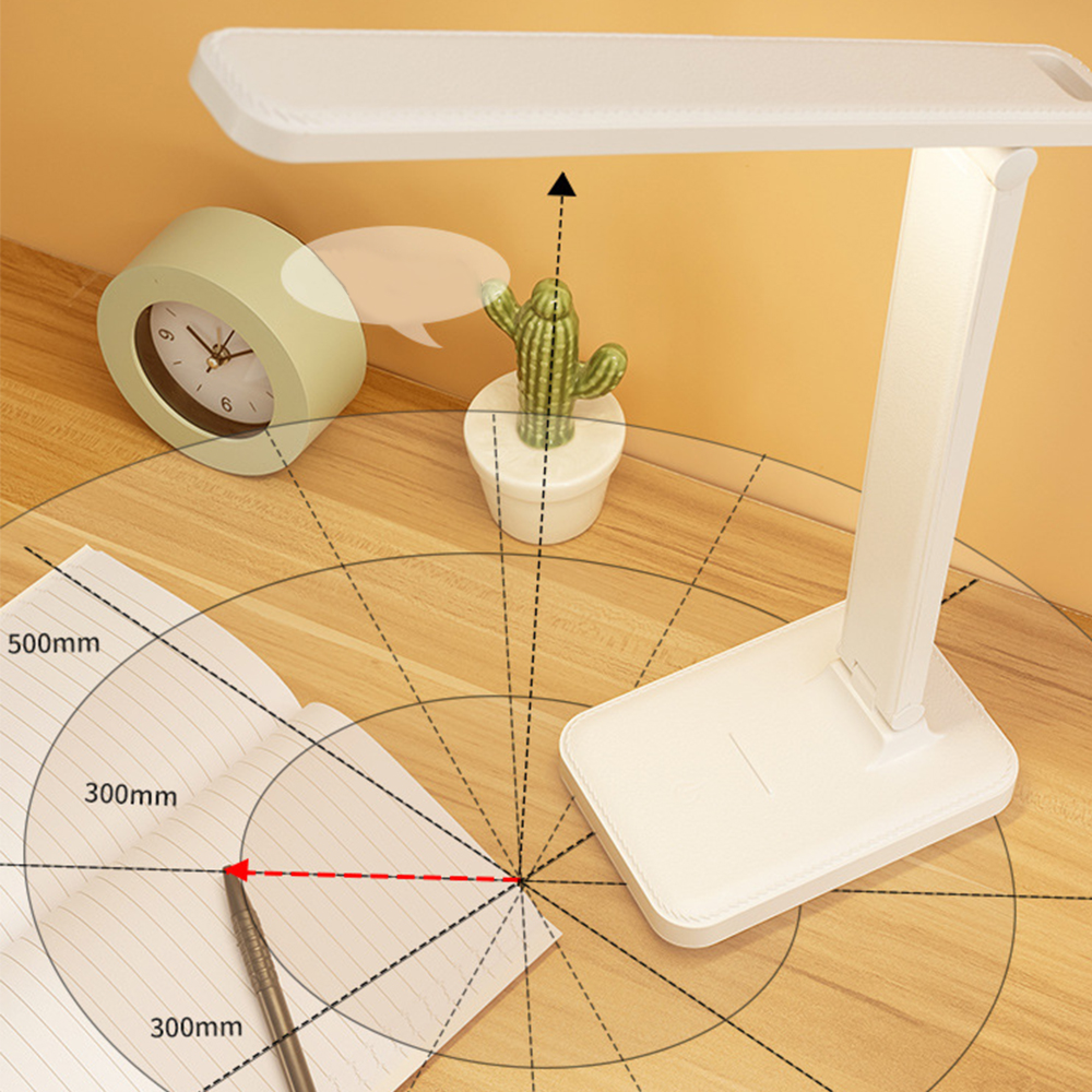 Ein weißer Schreibtisch mit Lampe, Uhr, Kaktus und Notizbuch.