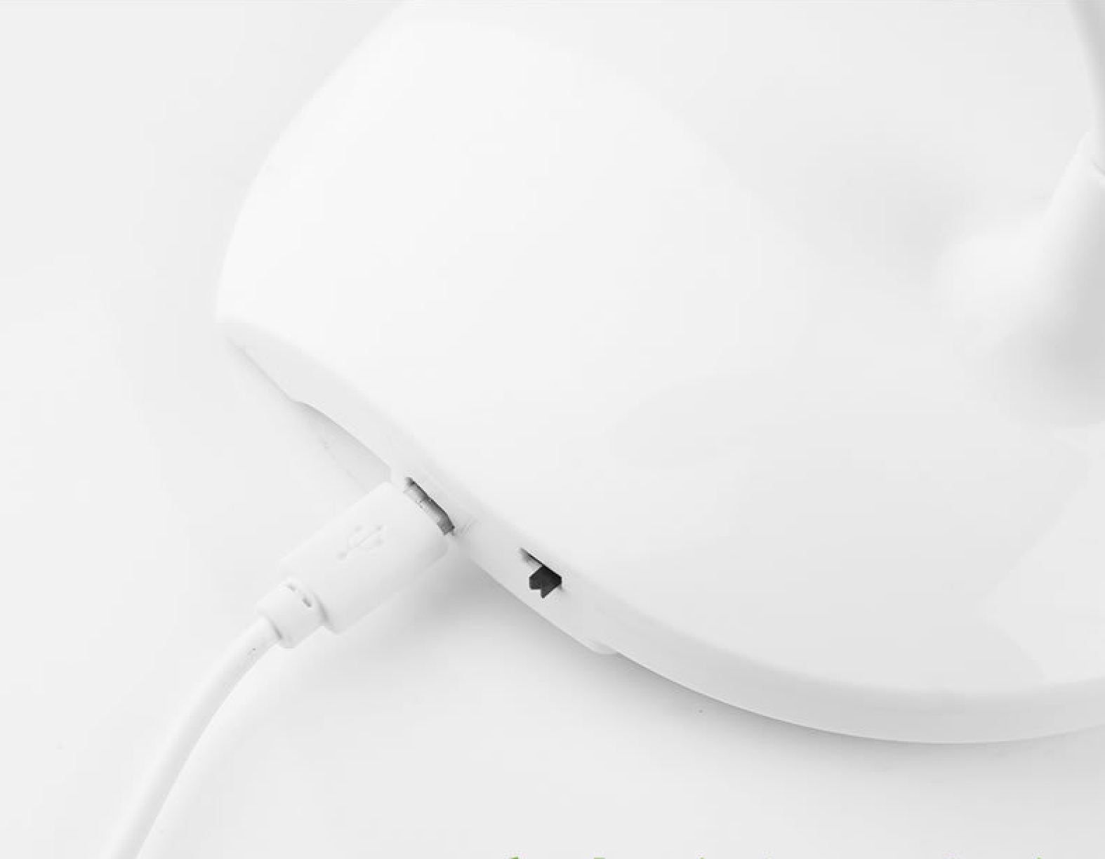 Ein weißes USB-Kabel ist in eine weiße Lampe eingesteckt.