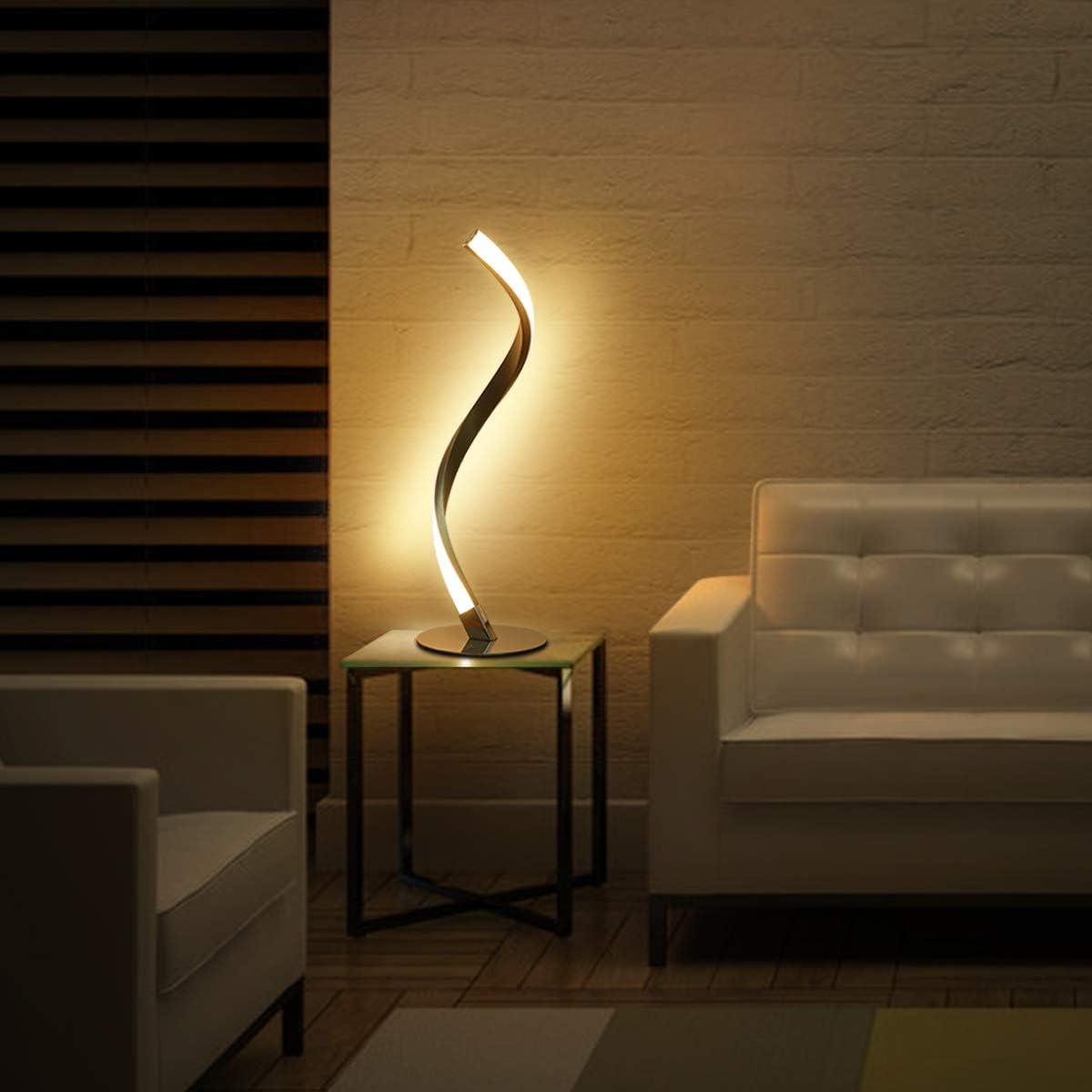 Moderne Lampe mit geschwungenem Design auf einem Beistelltisch zwischen zwei Sofas.