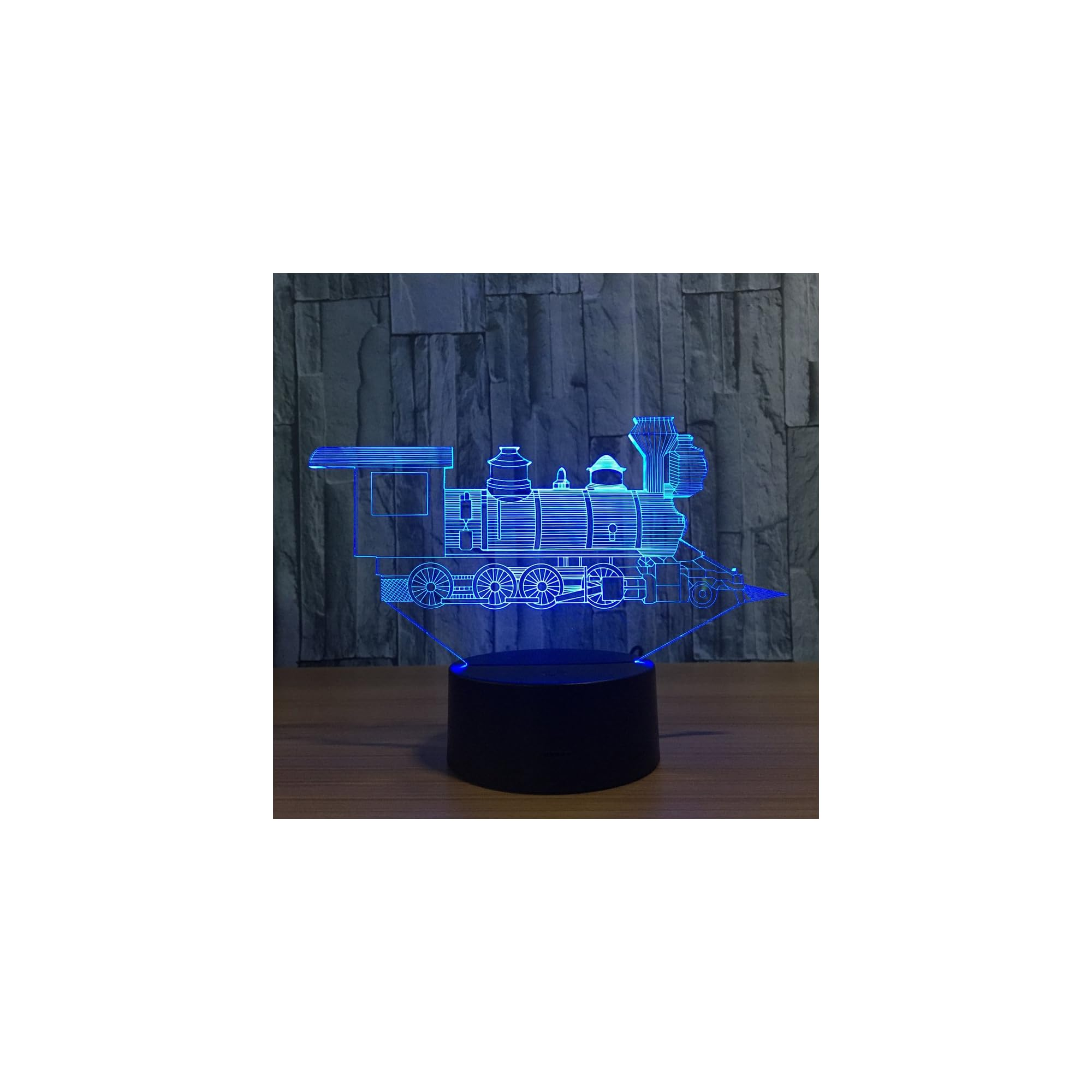 Eine blaue Lokomotive als 3D-Lampe auf einem dunklen Sockel vor einer Steinwand.