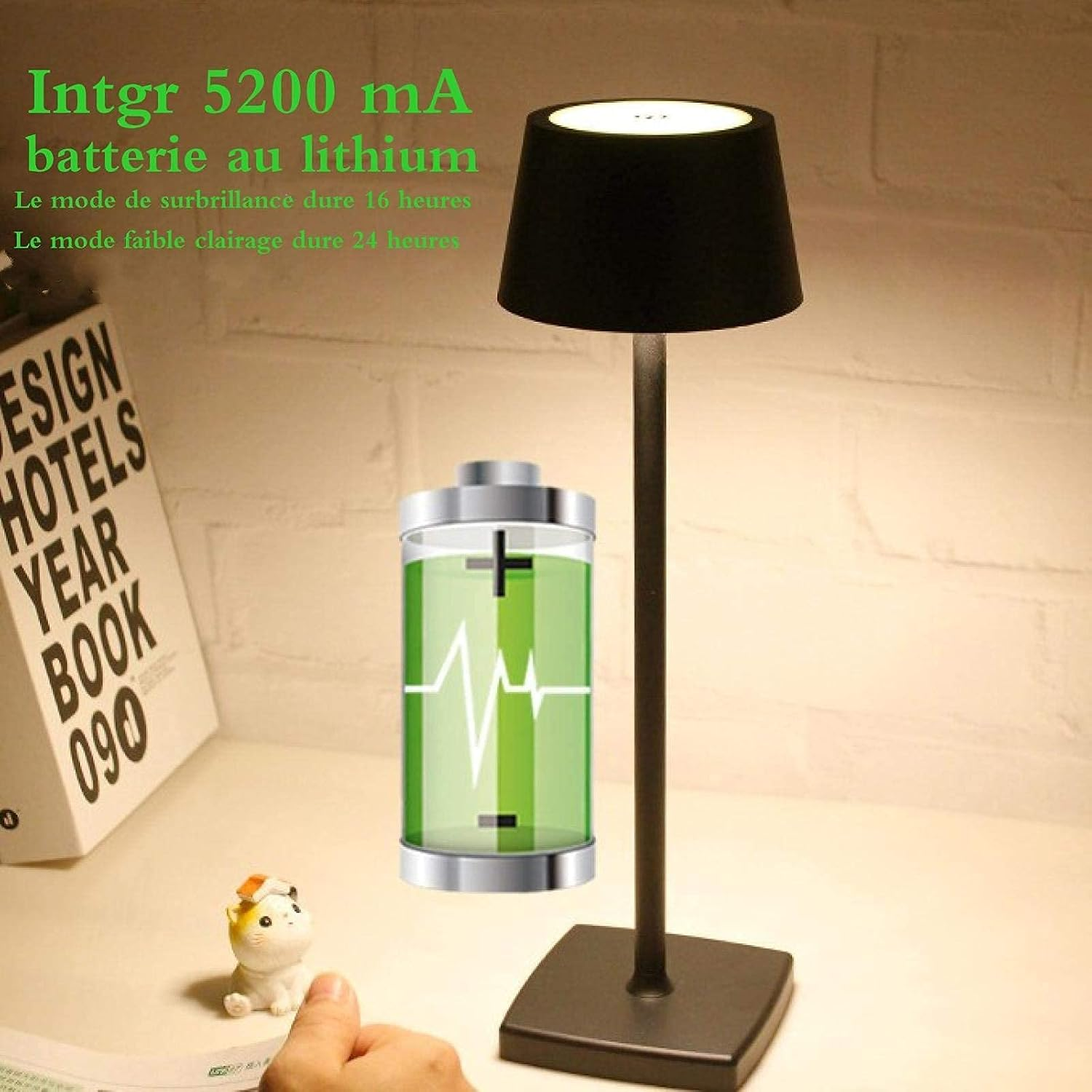 Eine schwarze Lampe mit einem Akku-Symbol daneben, auf einem Schreibtisch.