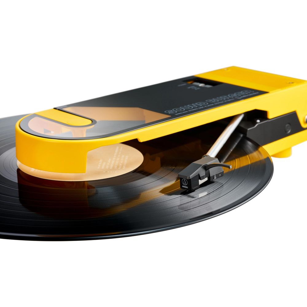Un giradischi giallo con braccio nero su un disco in vinile nero.