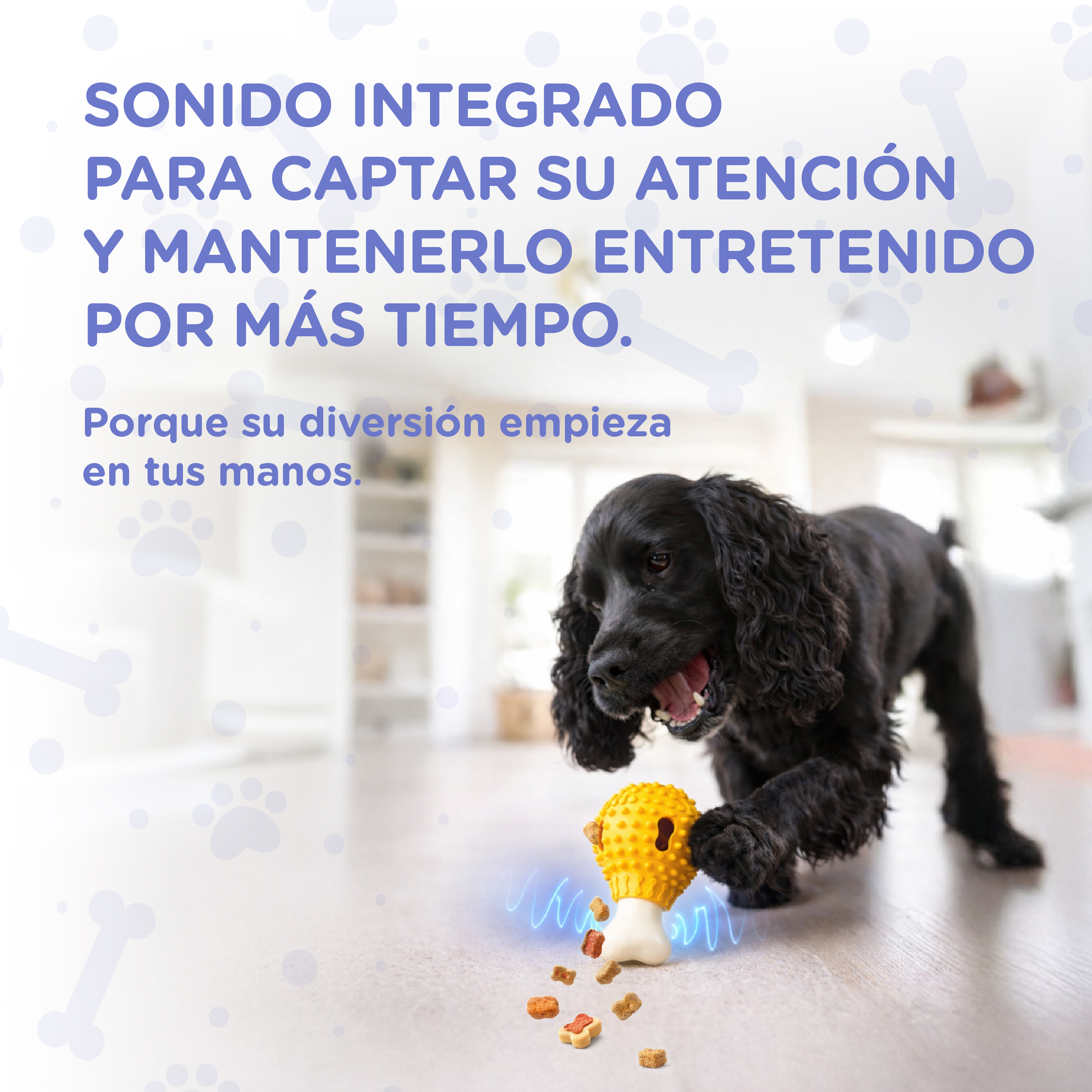 Un perro negro juega con un juguete amarillo del que caen golosinas.