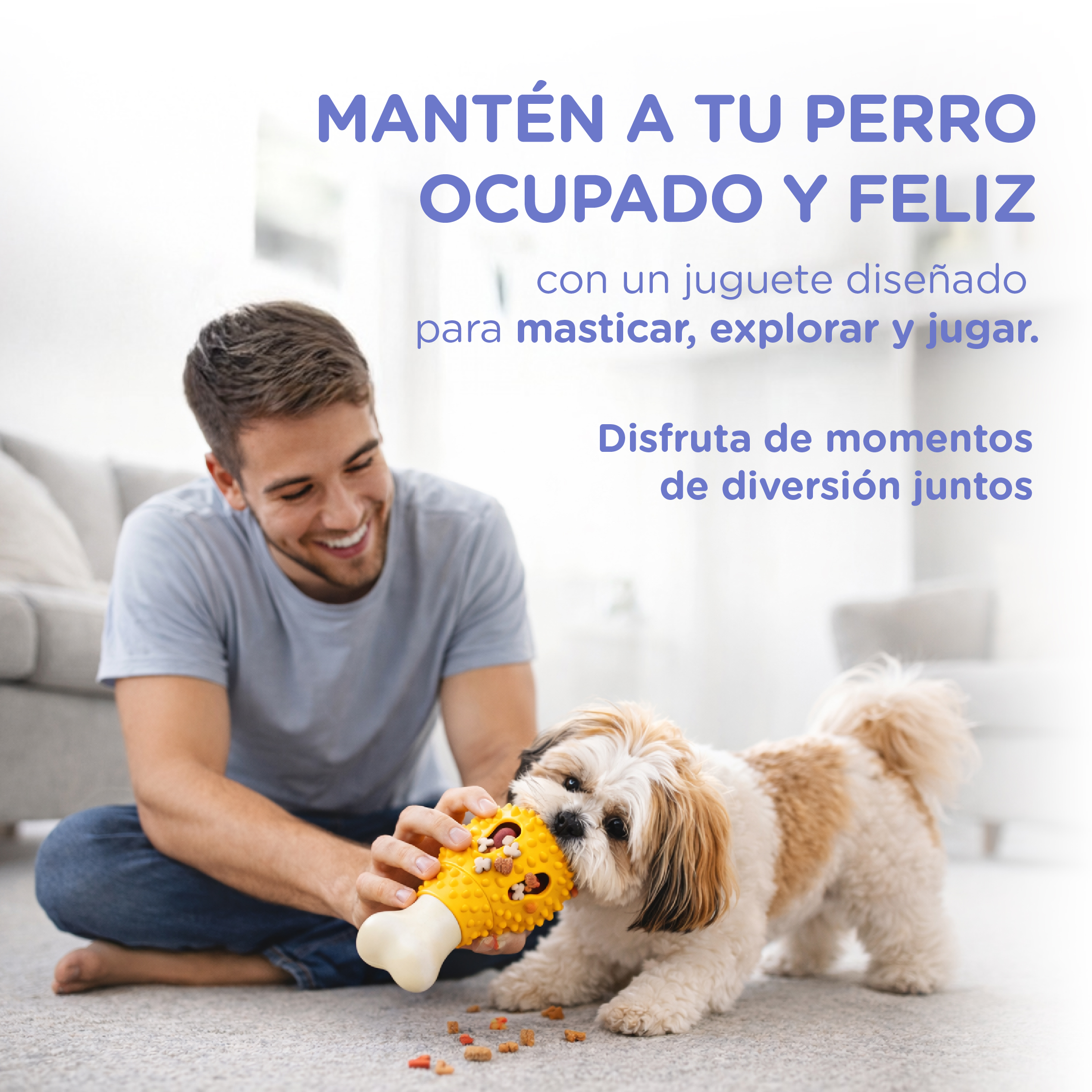 Hombre da a perro un juguete amarillo en forma de pata de pollo.