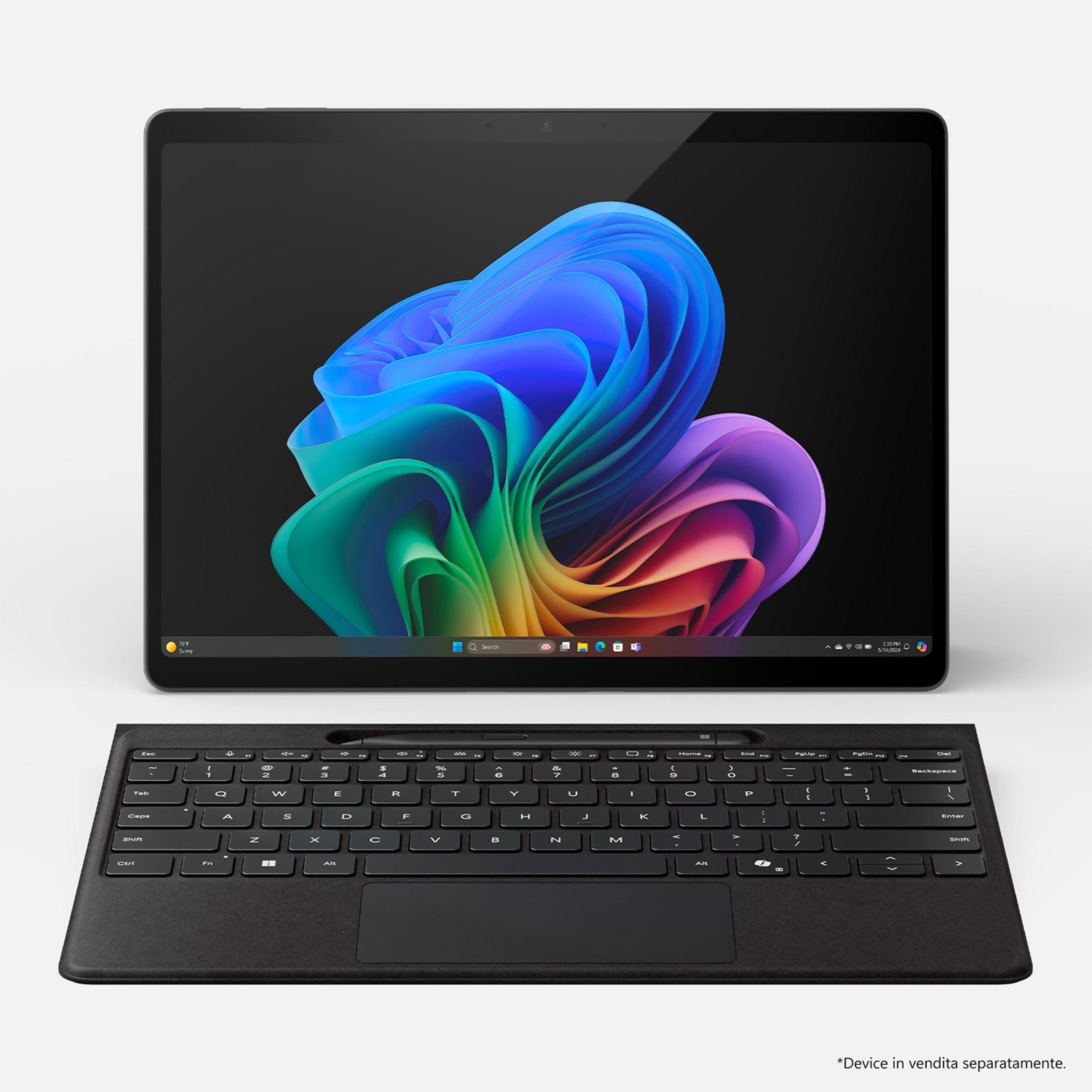 Un laptop con tastiera collegata visualizza uno sfondo colorato.