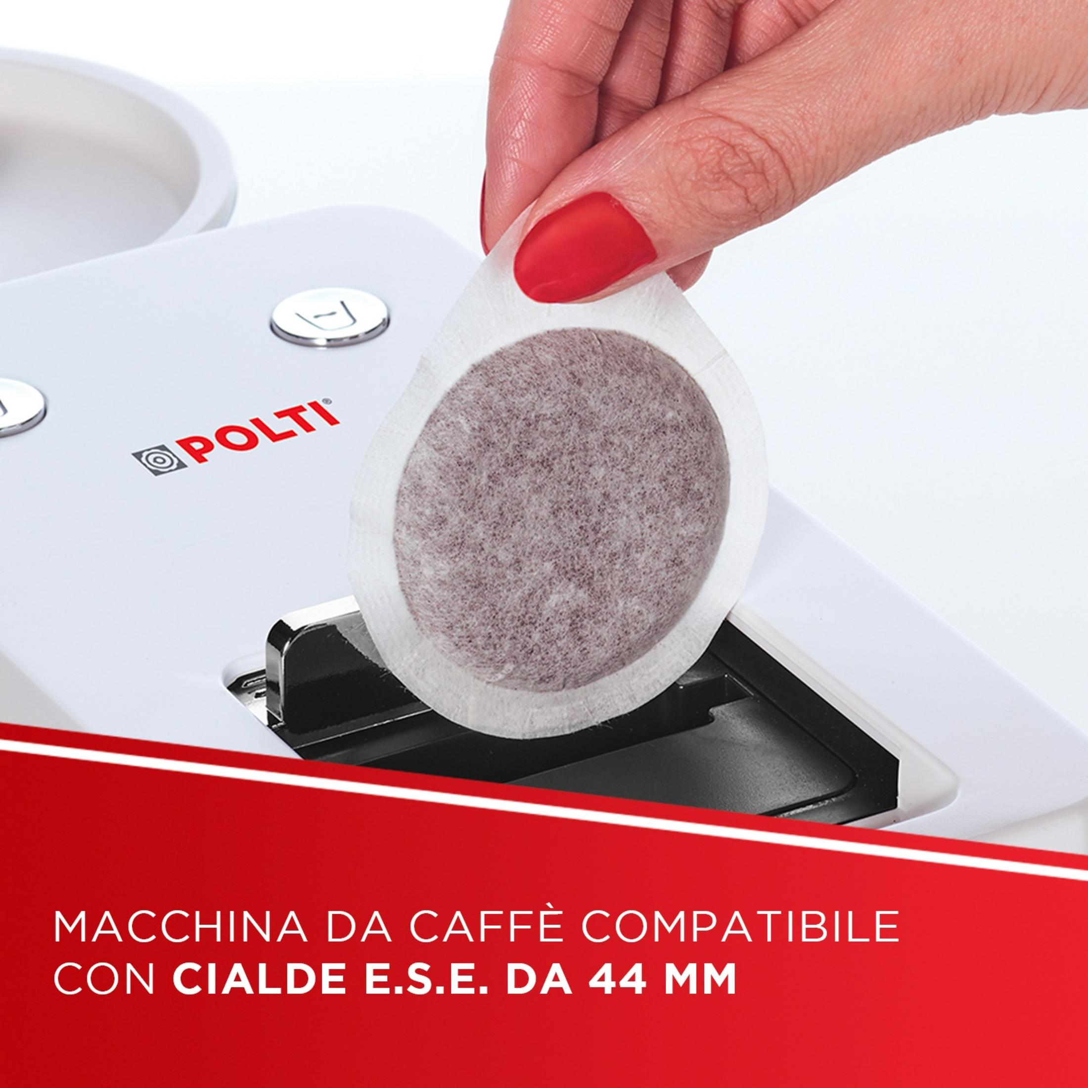 Una mano con esmalte rojo coloca una cápsula de café en una cafetera blanca.