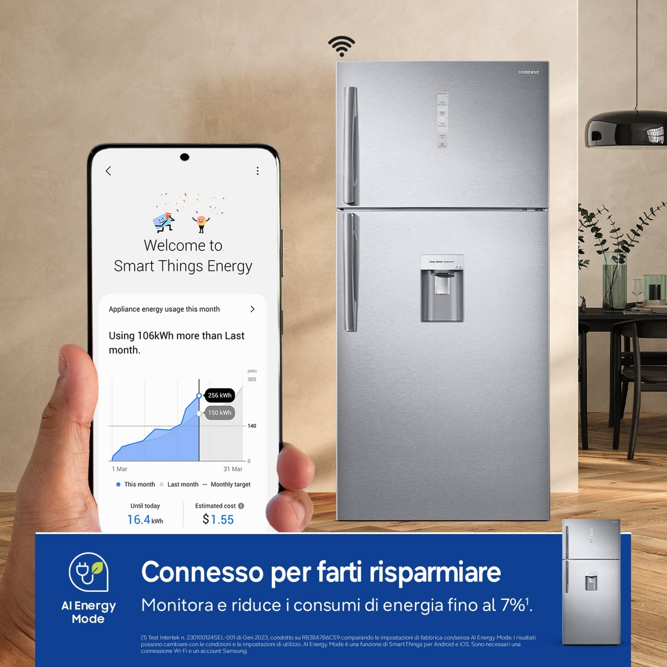 Uno smartphone mostra dati sui consumi energetici accanto a un frigorifero argentato.