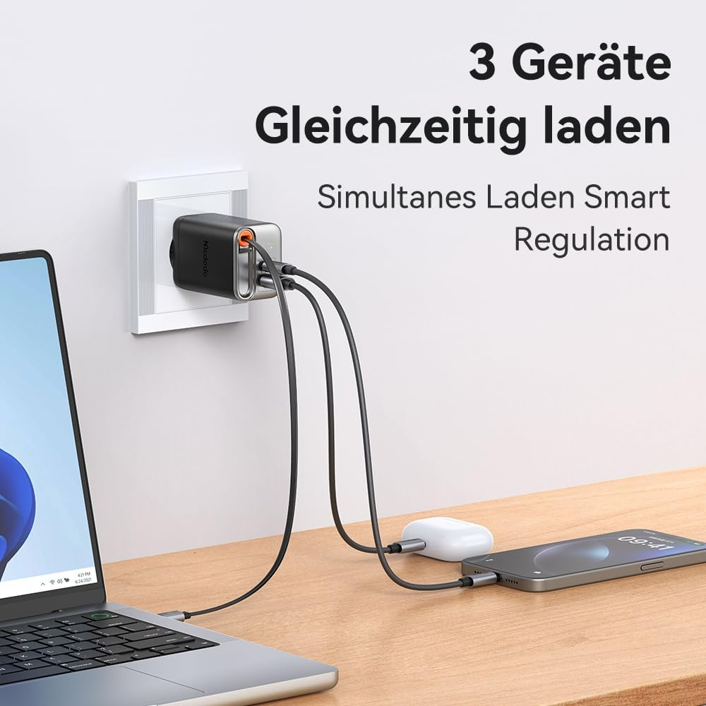Ein Ladegerät lädt drei Geräte gleichzeitig: Laptop, Kopfhörer und Smartphone.