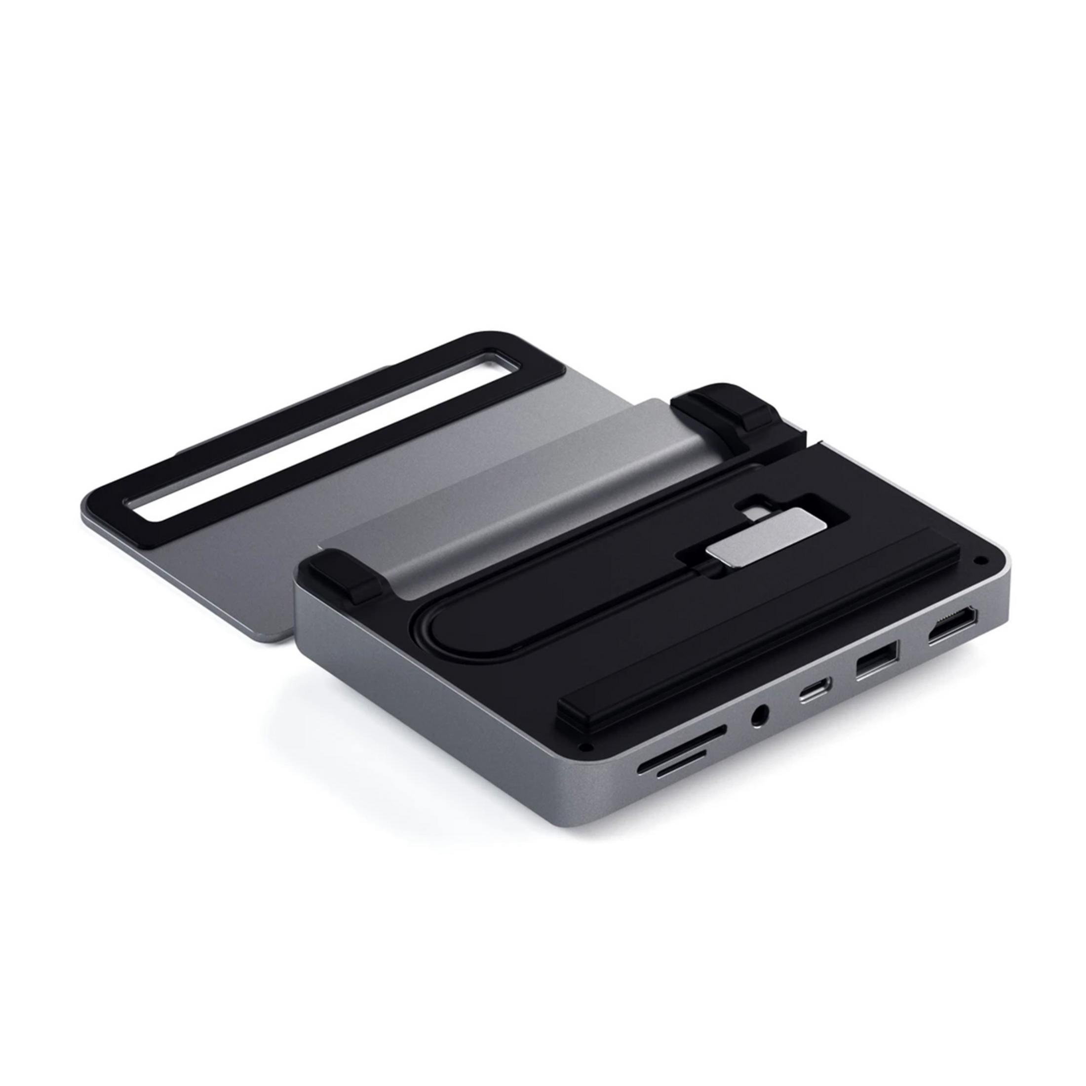 Hub USB-C gris con tapa abierta, mostrando ranuras para tarjetas SD y puertos.