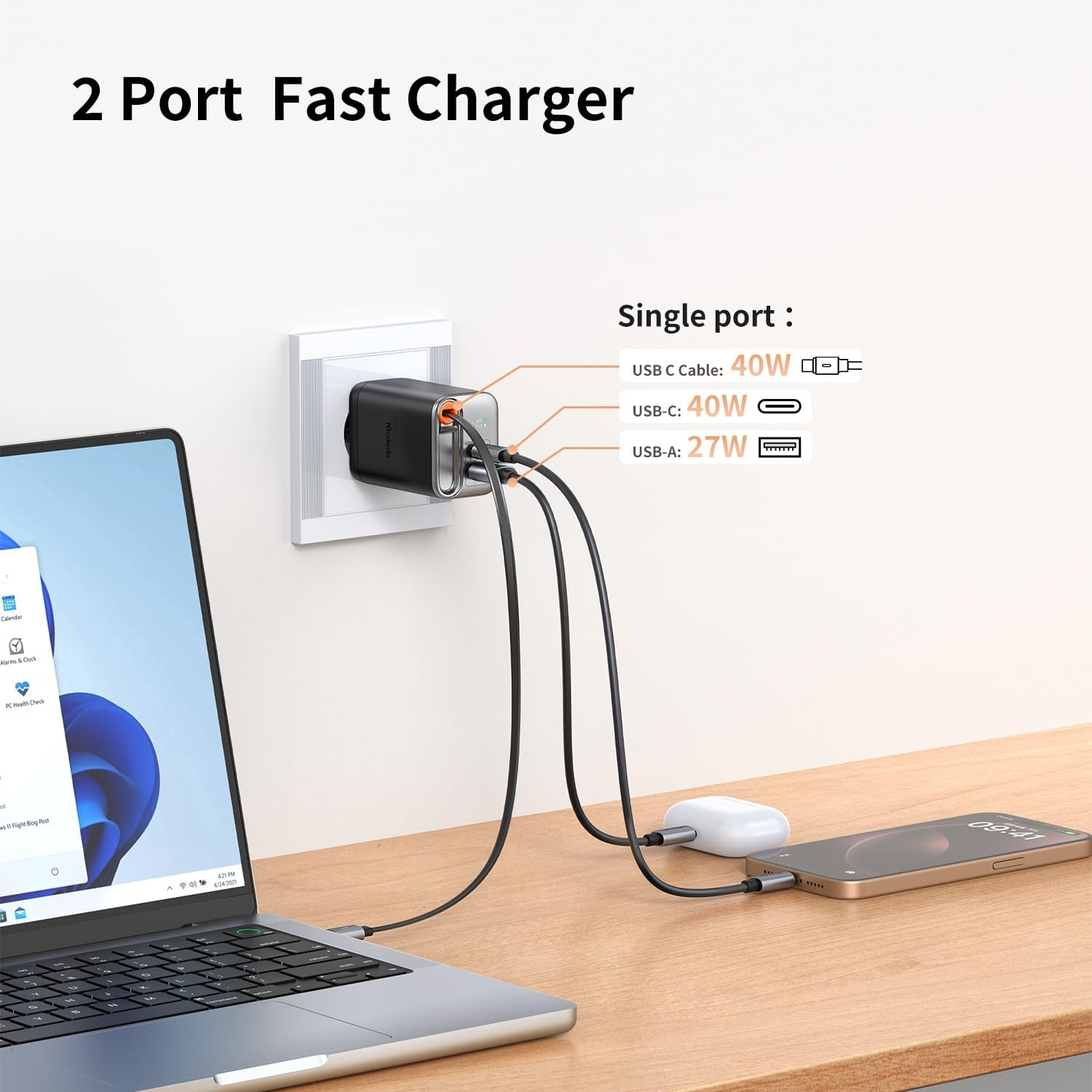 Ein schwarzes 2-Port-Schnellladegerät ist in eine Steckdose eingesteckt und lädt einen Laptop und ein Telefon.