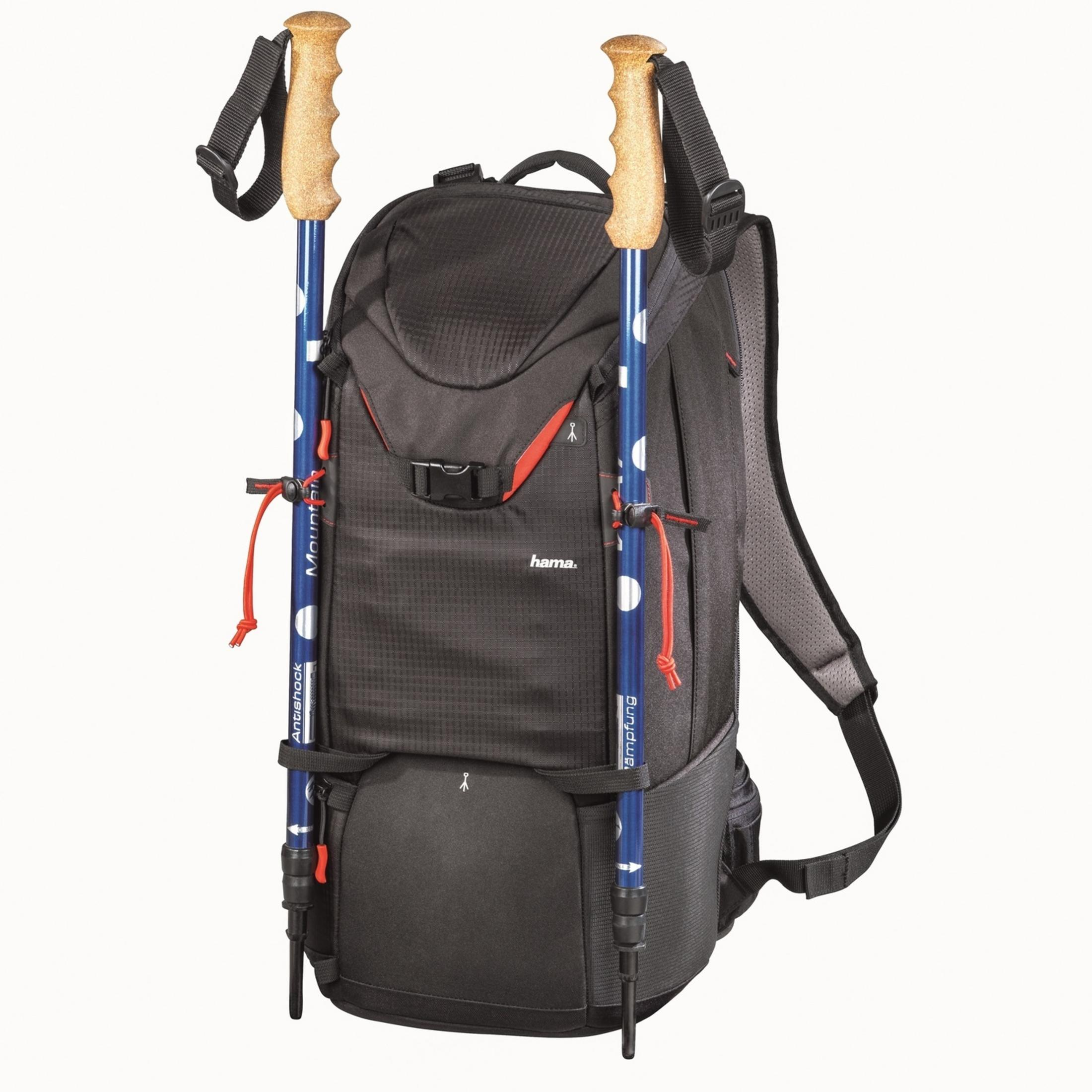 Schwarzer Rucksack mit Wanderstöcken und Korkgriffen, weißem Hintergrund.