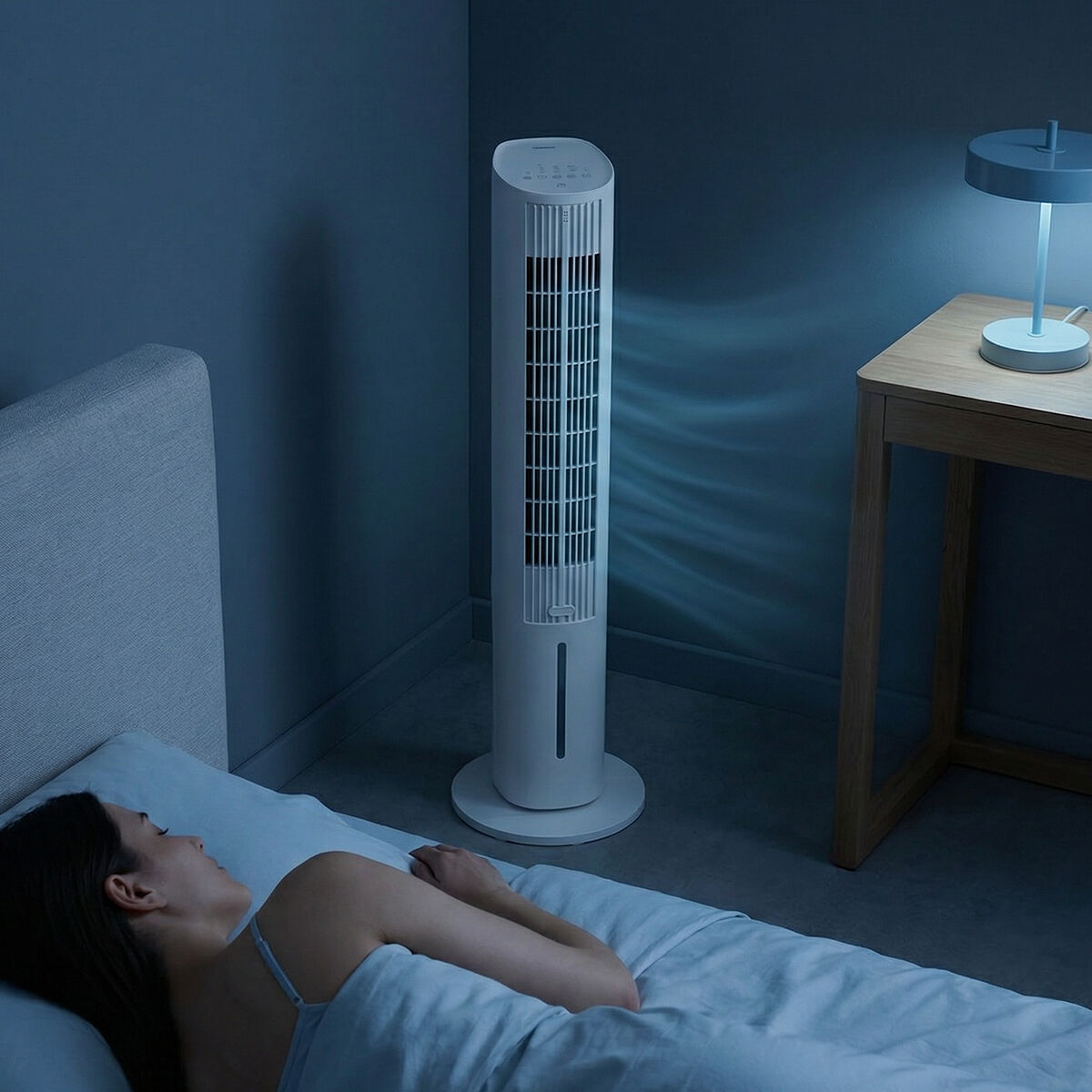 Eine Frau schläft im Bett, während ein Turmventilator läuft.
