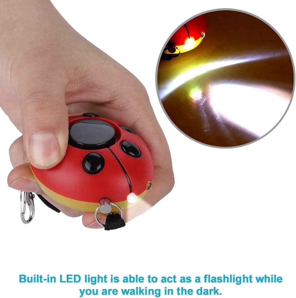 Eine Hand hält einen roten Marienkäfer-Anhänger mit LED-Licht. Ein Kreis zeigt das Licht.