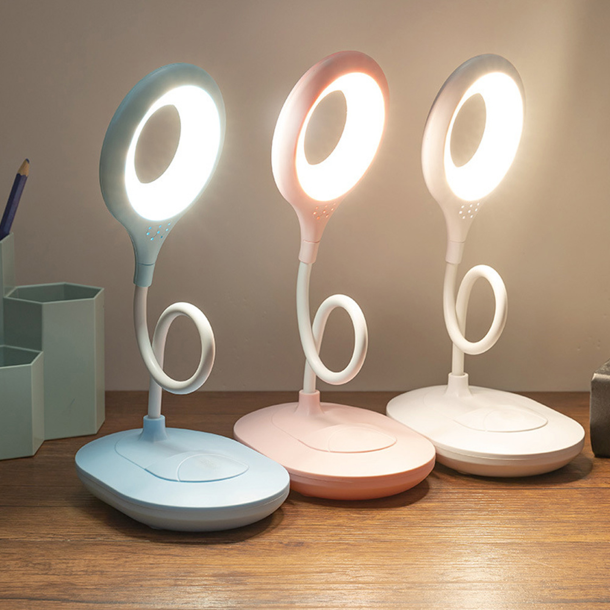 Drei Schreibtischlampen in Blau, Rosa und Weiß mit flexiblen Hälsen.
