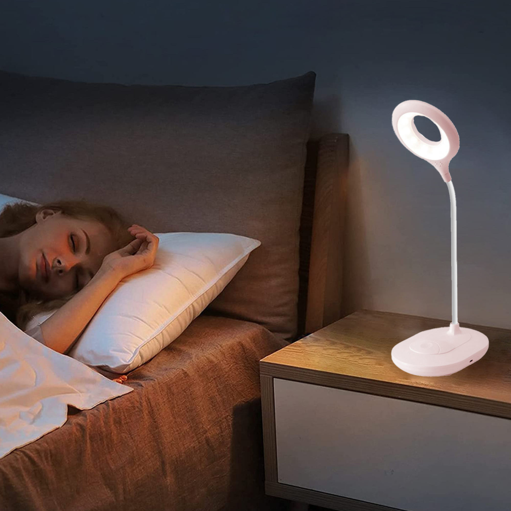 Eine Frau schläft im Bett, eine Nachttischlampe leuchtet.