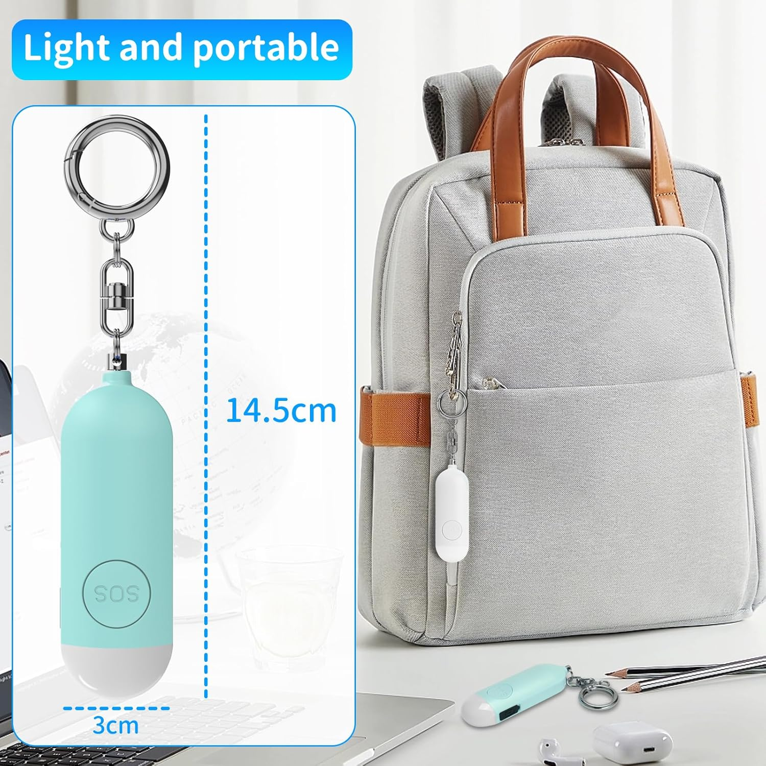 Hellblaue SOS-Schlüsselanhänger und grauer Rucksack auf einem Schreibtisch mit Laptop und Stiften.