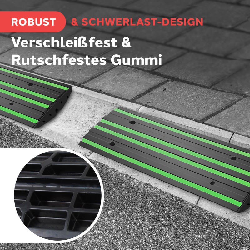 Schwarze Rampen mit grünen Streifen auf Gehweg. Detailansicht unten links.