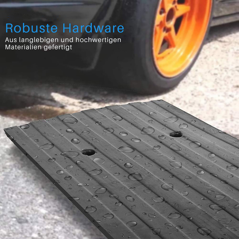Schwarze Gummirampe mit Wassertropfen, Autoreifen und orangefarbener Felge.