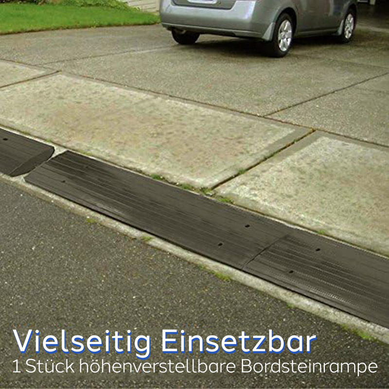 Schwarze Bordsteinrampen liegen an einer Straße, mit einem Auto im Hintergrund.