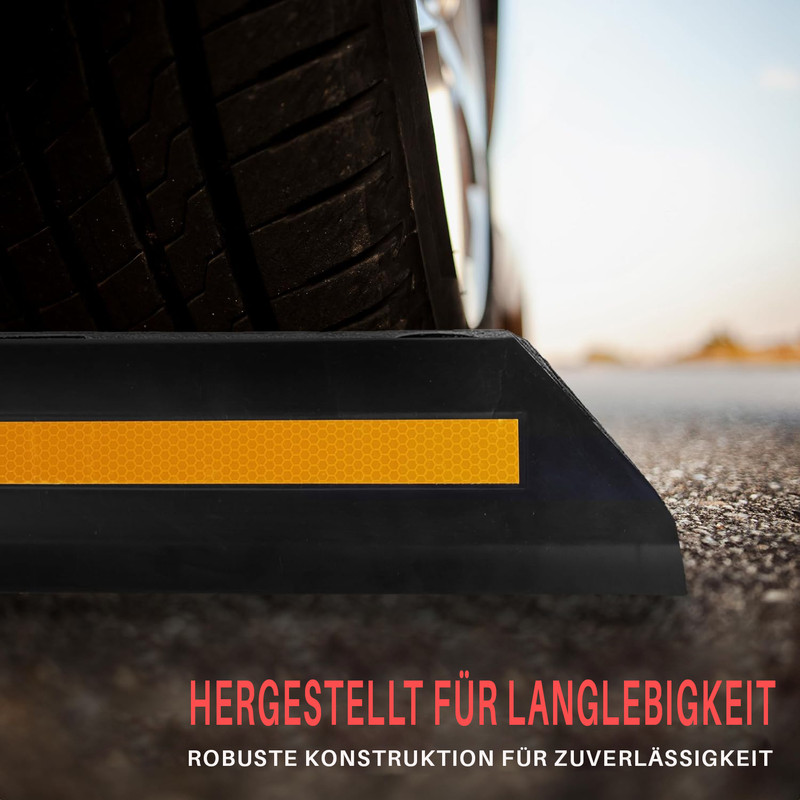 Ein Autoreifen ruht auf einem schwarzen Parkstopper mit gelbem Reflektor.