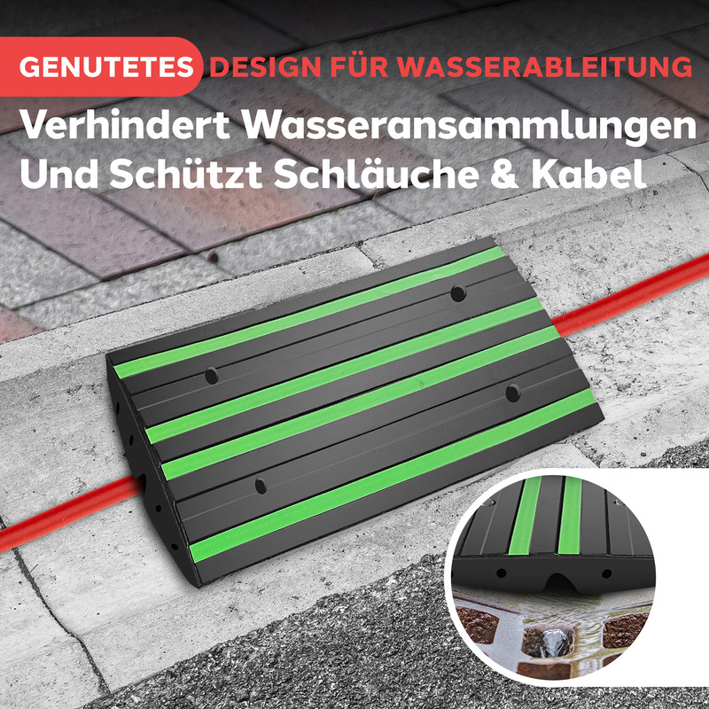 Schwarzer Kabel-/Schlauchschutz mit grünen Streifen, auf Kopfsteinpflaster.