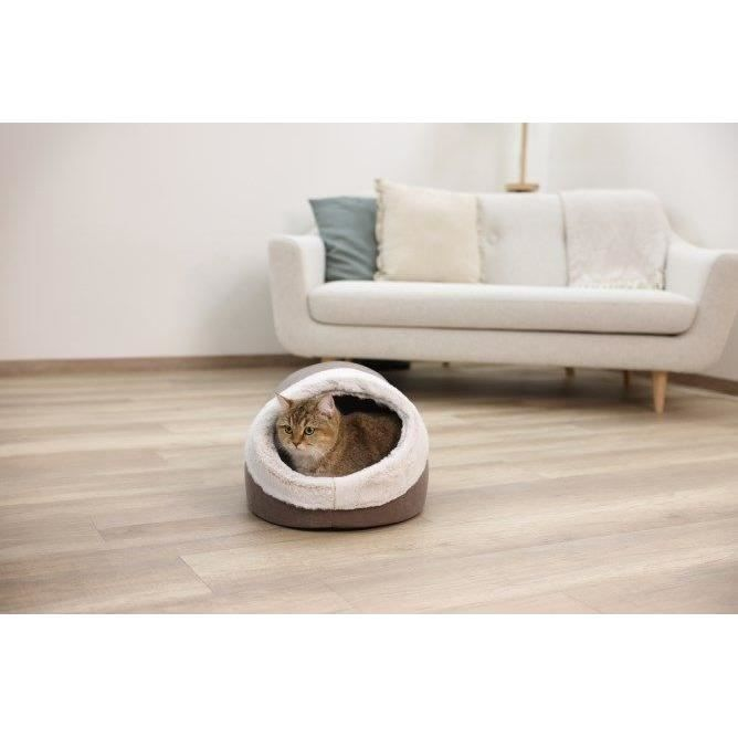 Eine getigerte Katze sitzt in einem gemütlichen braunen und weißen Katzenbett auf einem Holzboden.