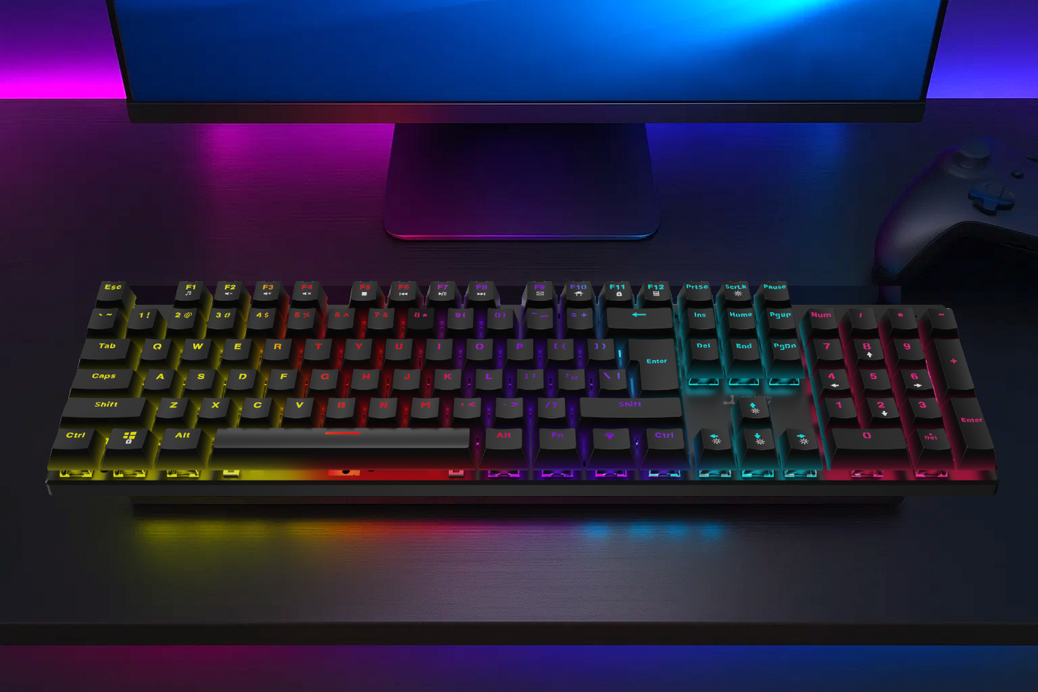 Czarna klawiatura z oświetleniem RGB przed monitorem i kontrolerem.