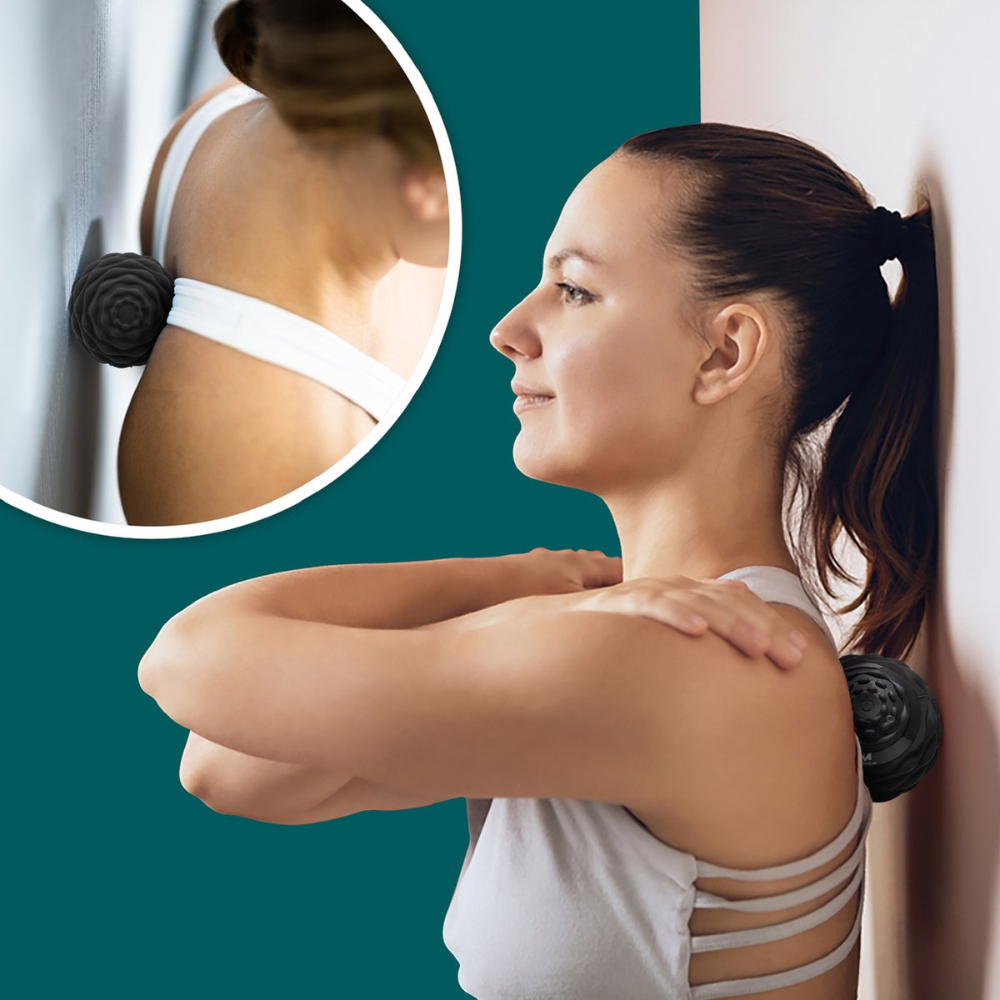 Mujer se apoya en pared usando bola de masaje para aliviar dolor.