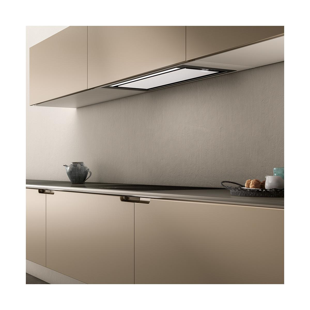 Cucina moderna con mobili beige, cappa e piano cottura.