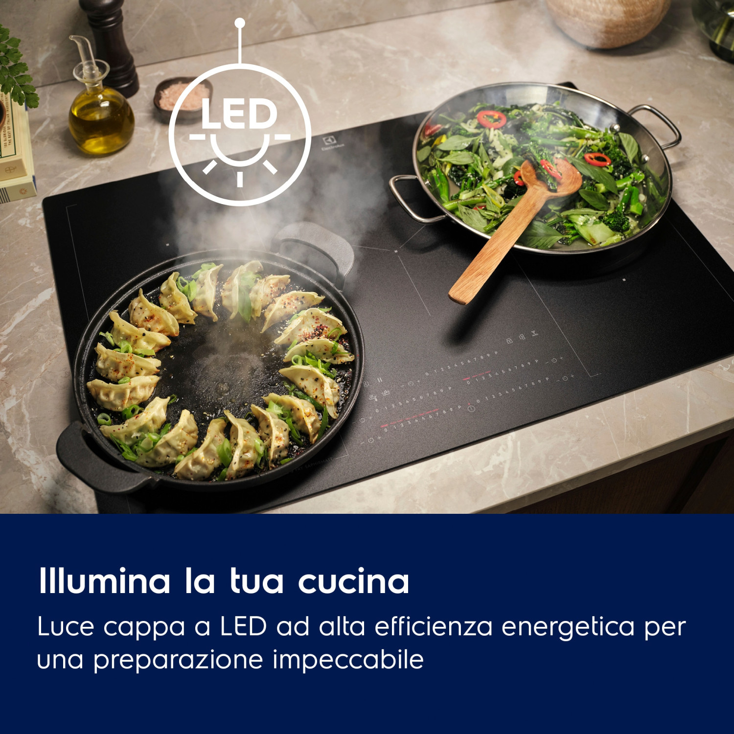 Una cappa con luce LED sopra un piano cottura che cuoce gyozas e verdure.
